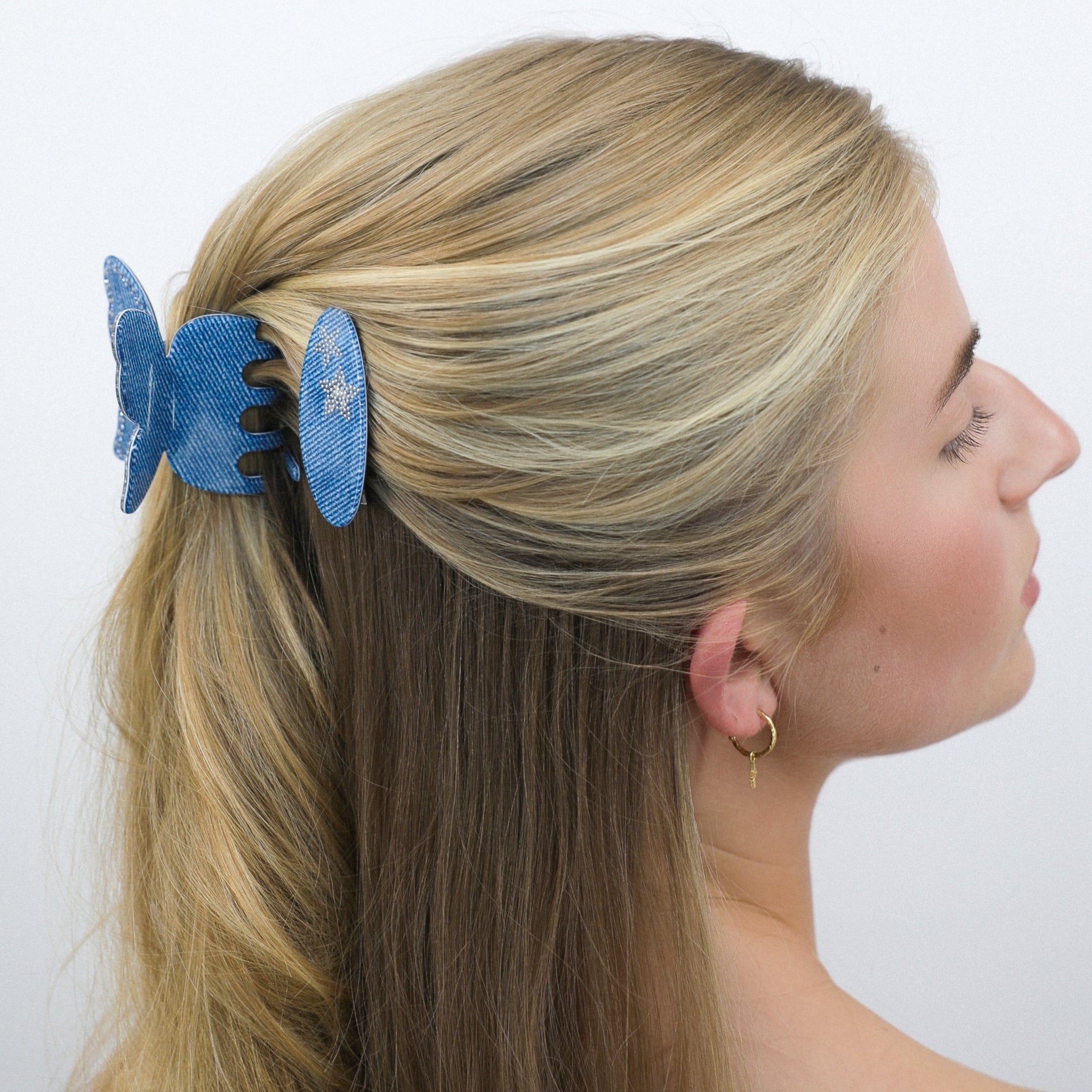 Woman with Luna Wave blue denim butterfly hair claw clip in her hair against a white background