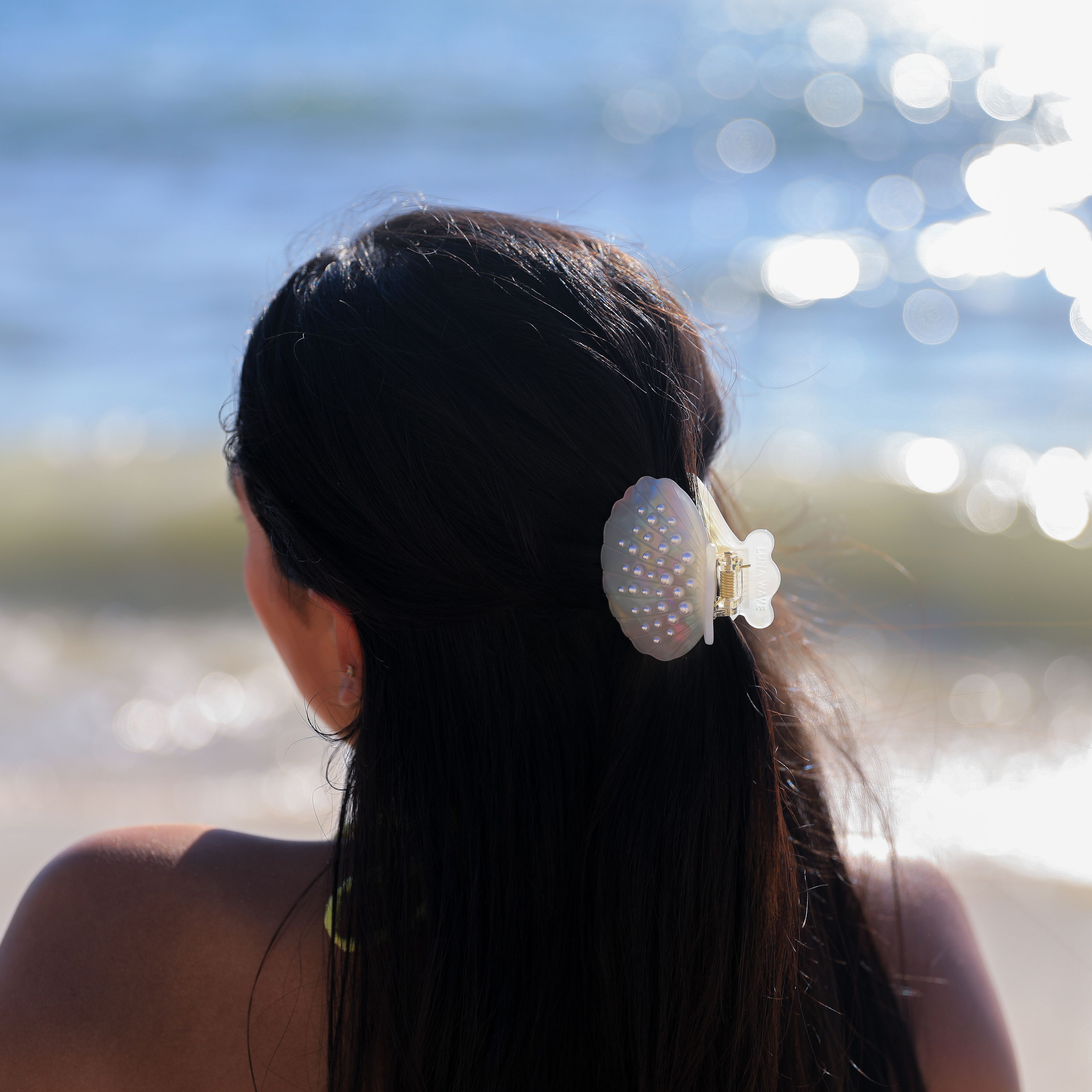 Pearlescent white hair claw with shell detail and rhinestone accent by Luna Wave