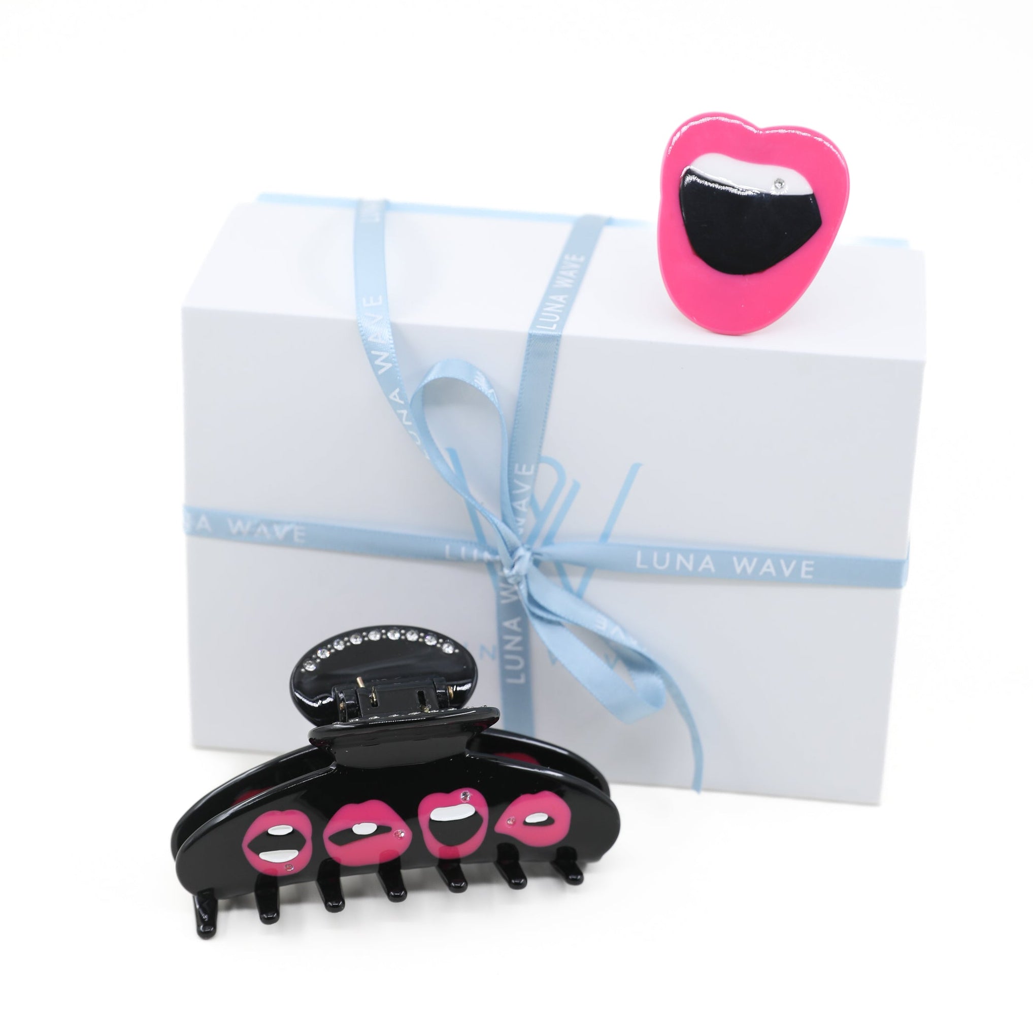Black hair clip with pink lips on a white background