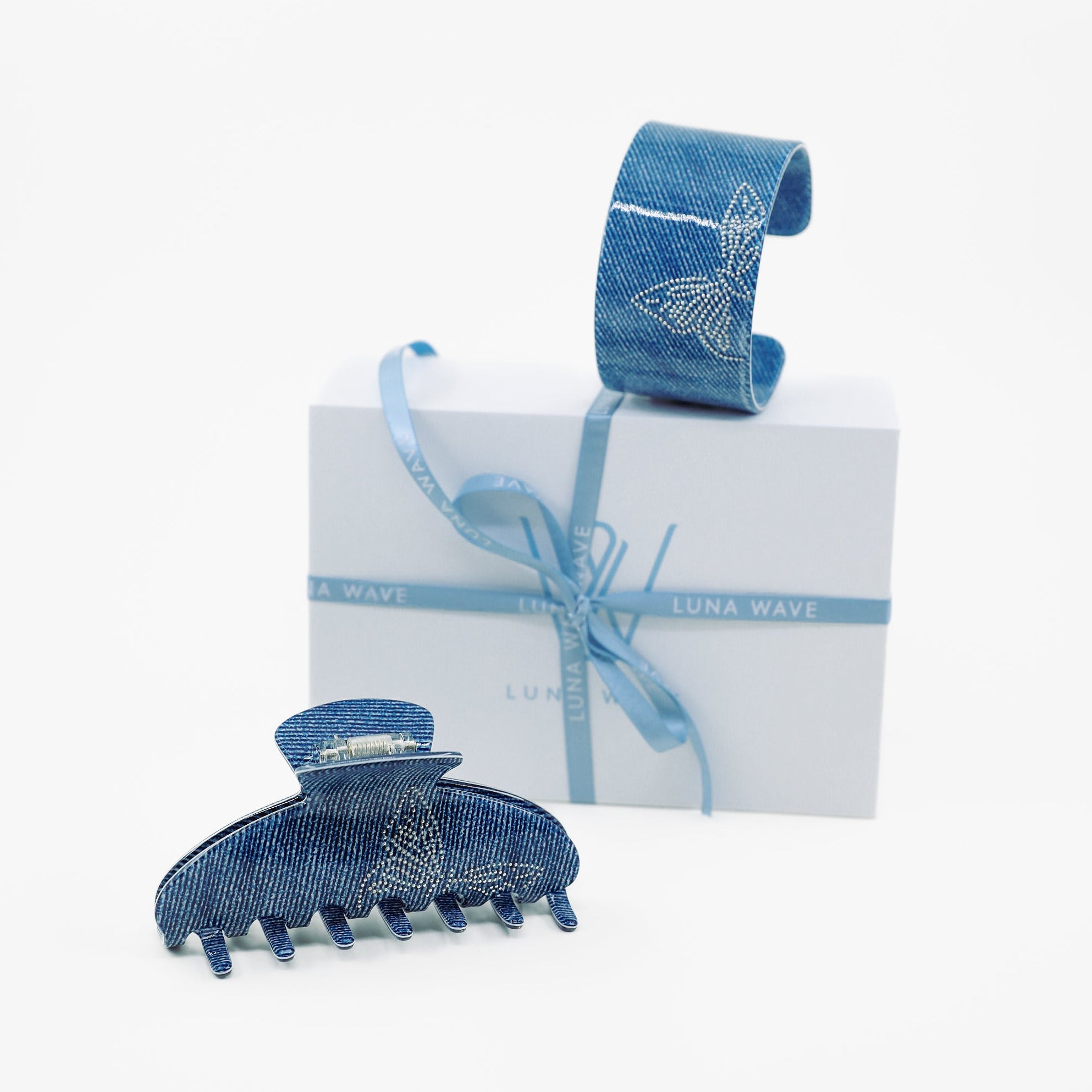Blue denim hair clip and ribbon with a white box on a white background