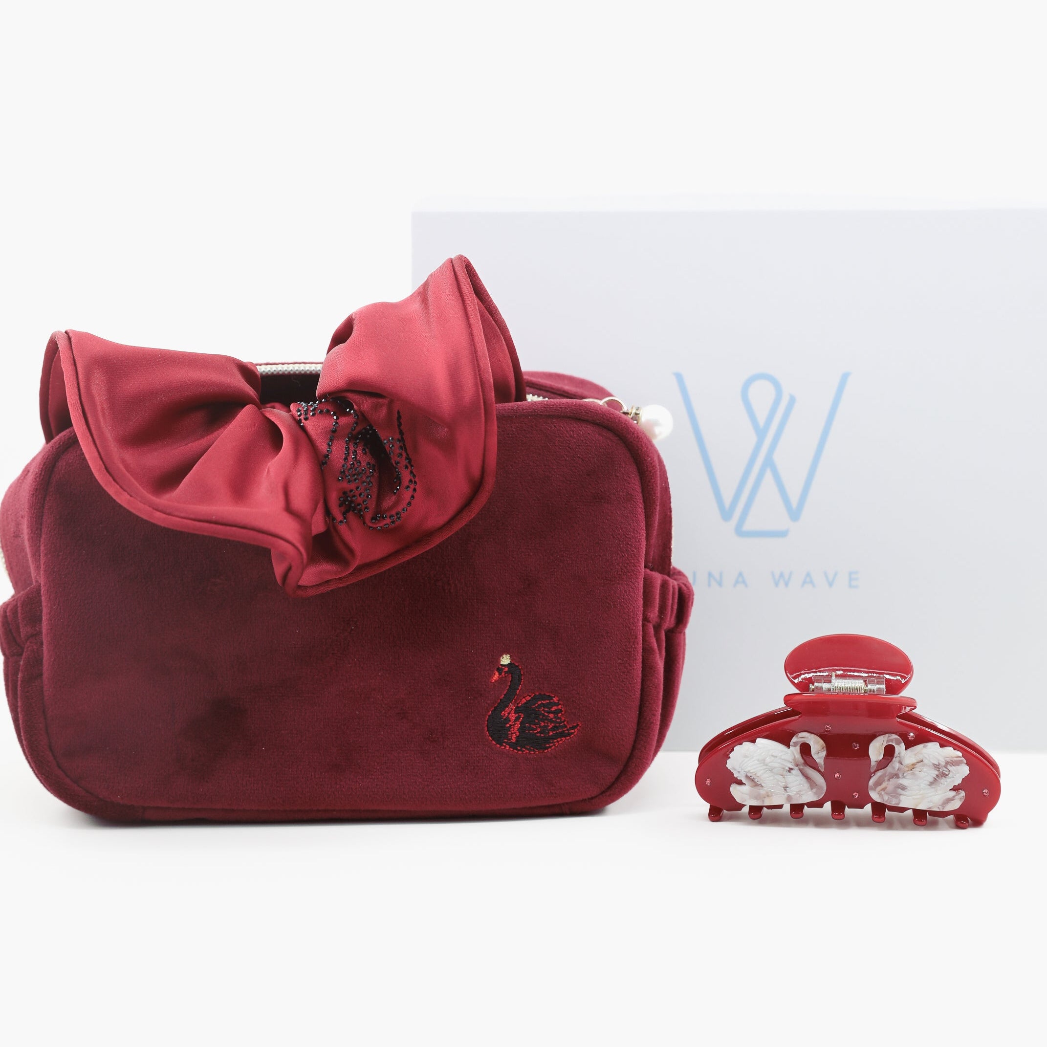 Red handbag with a large bow and a small decorative item on a white background