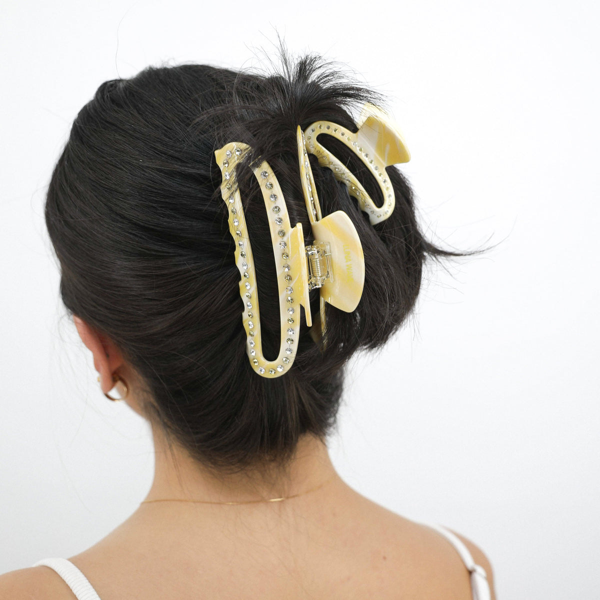 Person with a Luna Wave yellow butter cloud midi hair claw clip in their hair against a white background