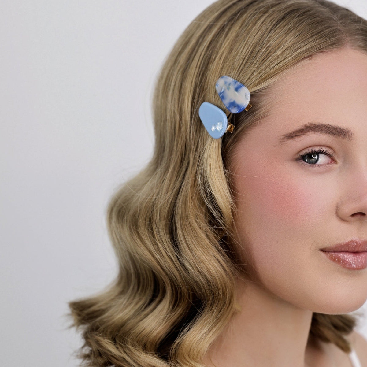 Woman with styled hair wearing a Luna Wave blue sky petite hair clips against a plain background