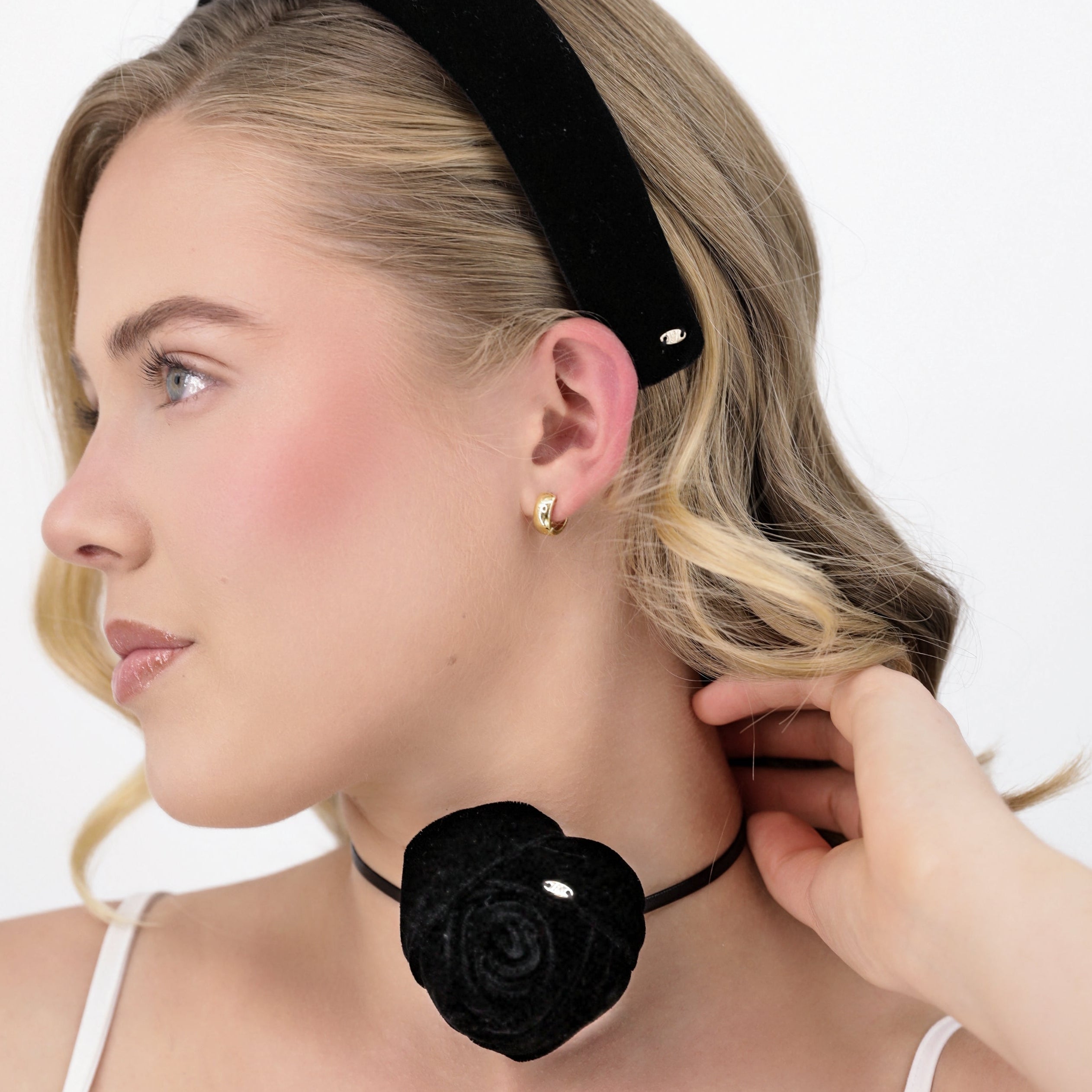 Woman wearing a Luna Wave black noir headband and black rose-shaped choker against a white background