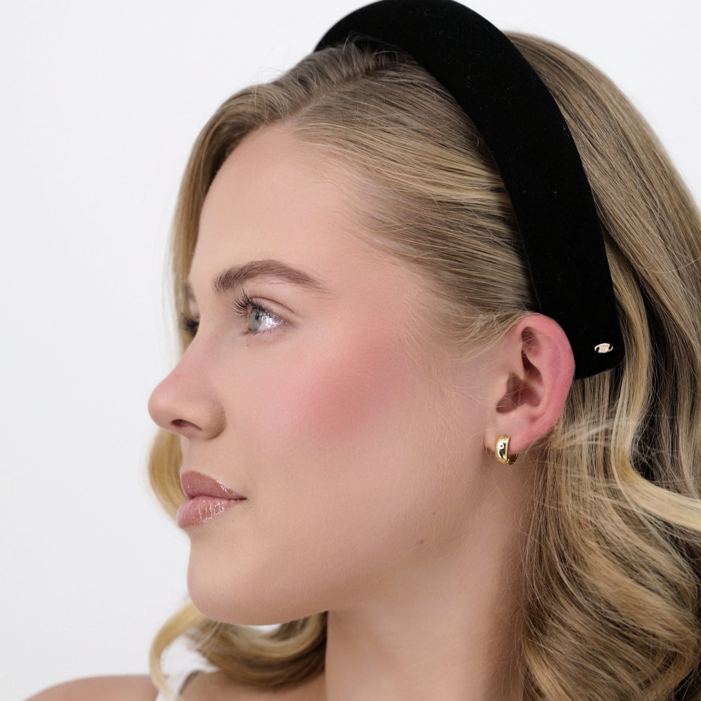 Woman wearing a Luna Wave black moir amelie headband on a white background