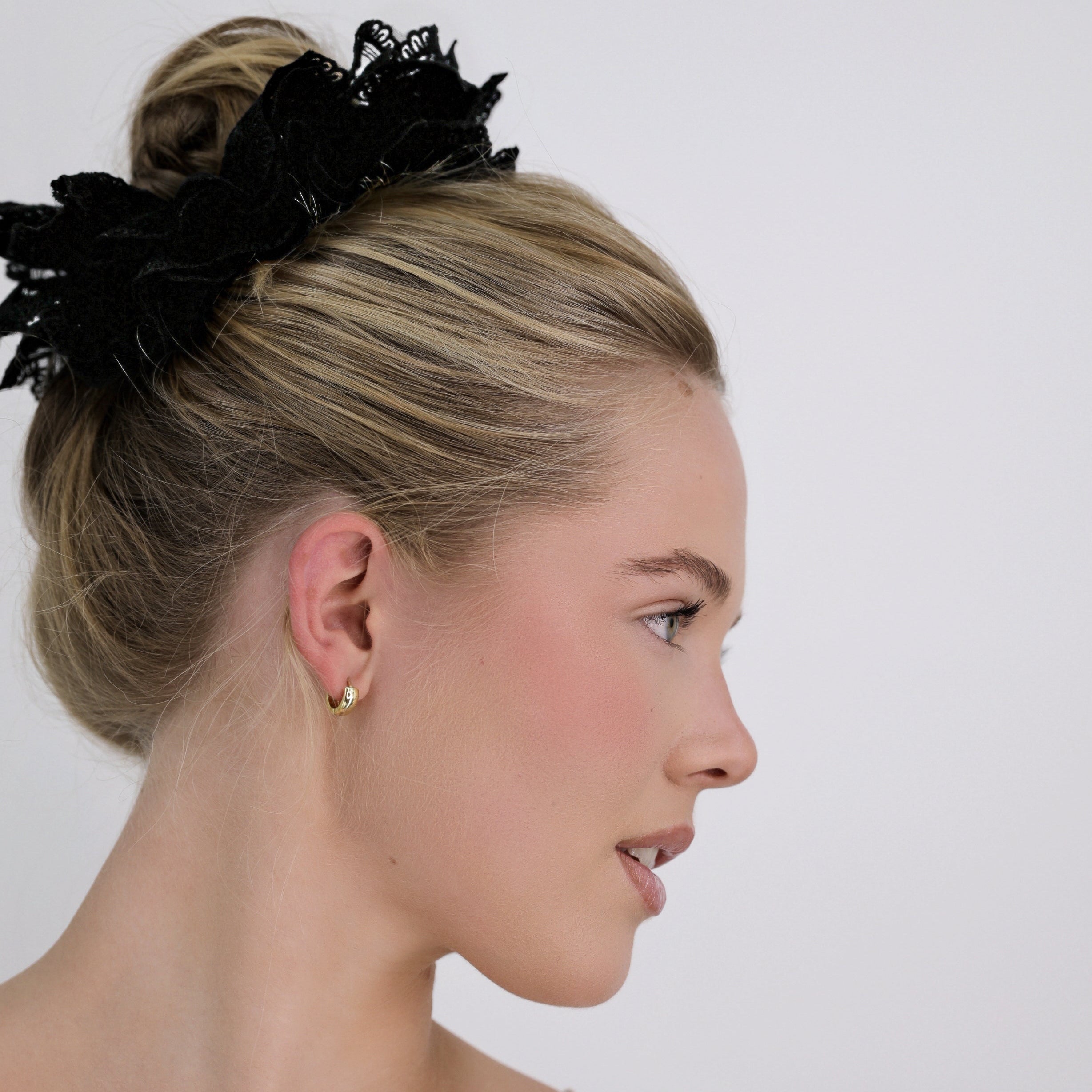 Woman with a Luna Wave black noir lace scrunchie on a plain background