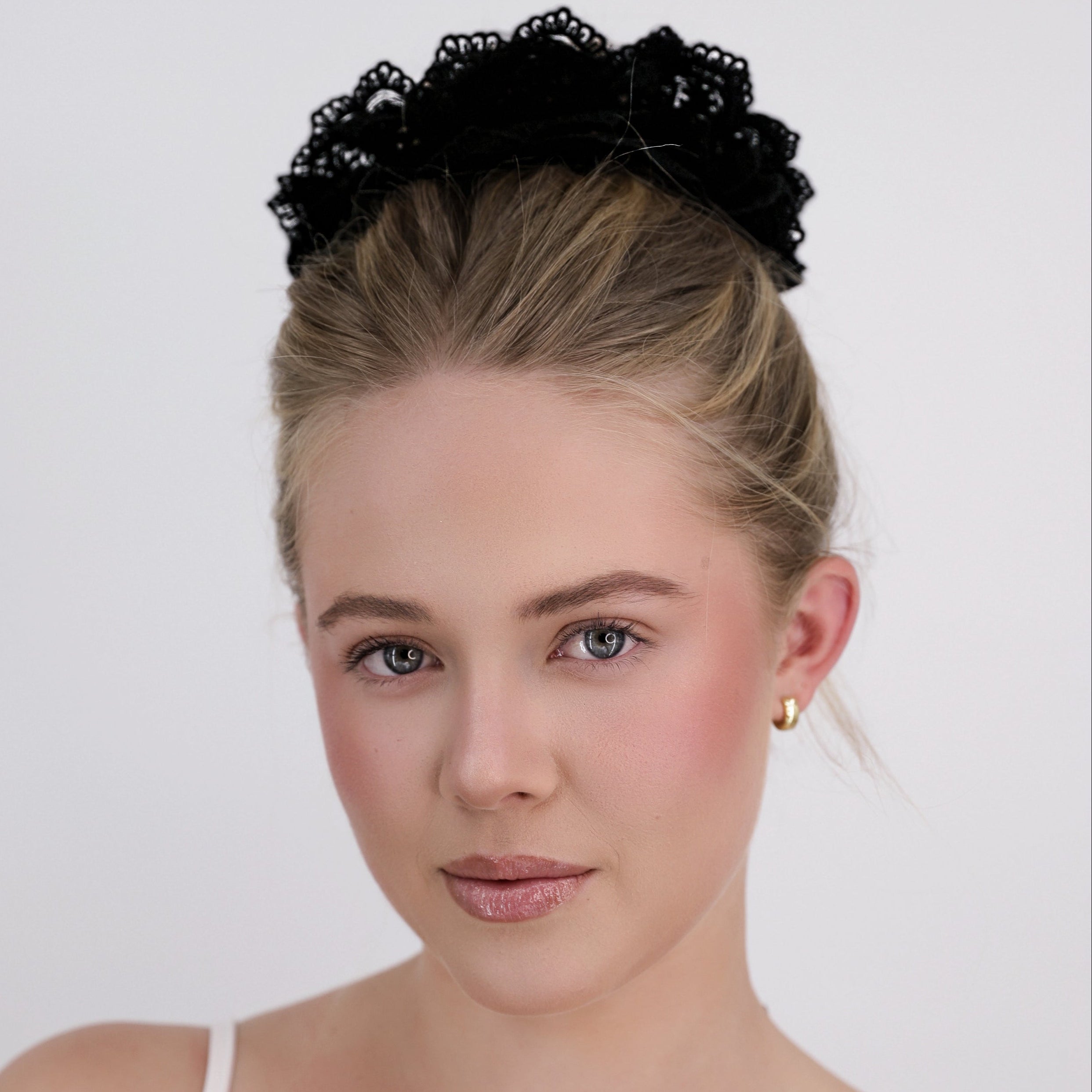 Woman with a Luna Wave black noir lace scrunchie hair accessory on a white background