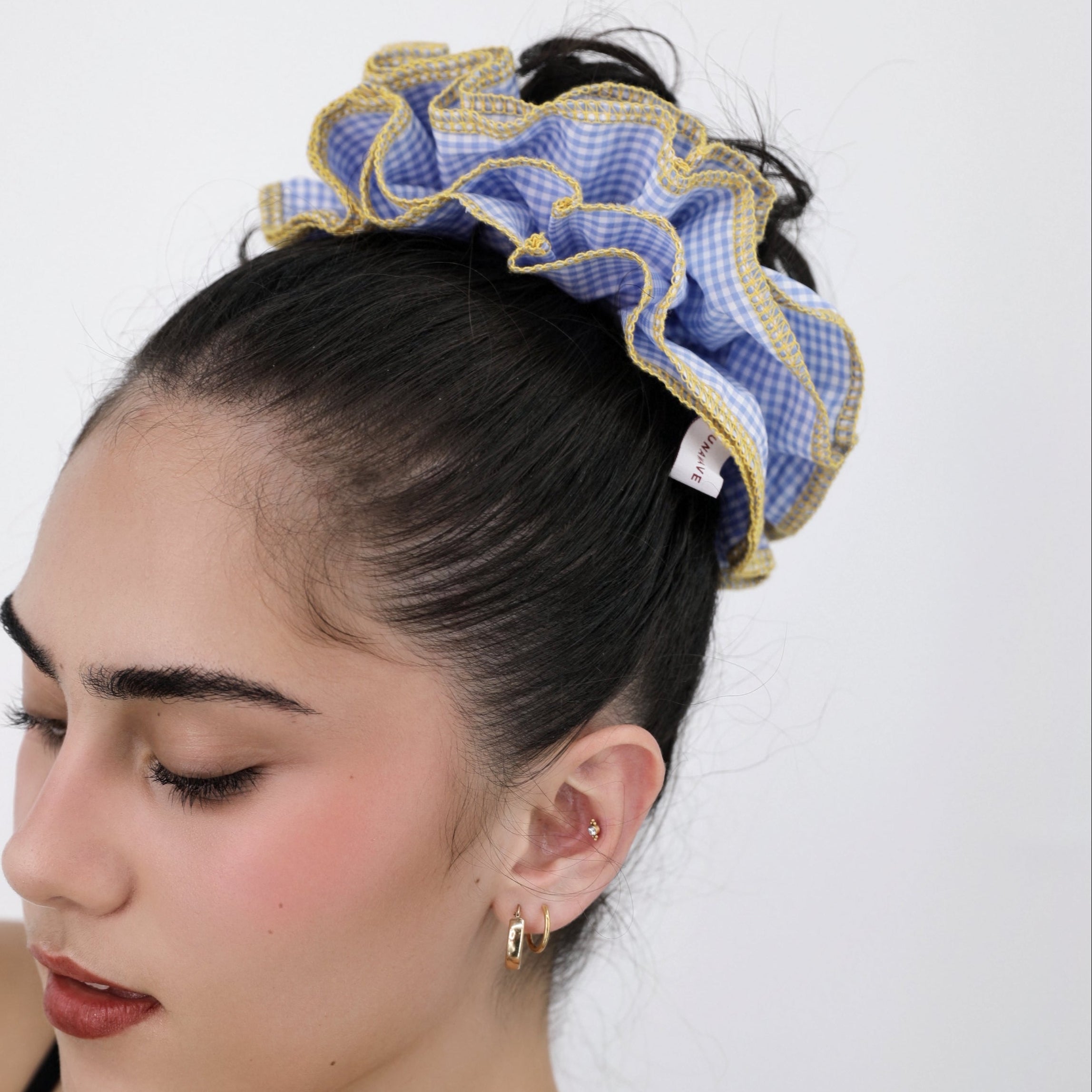 Woman with a Luna Wave blue check darling duo scrunchie on a white background