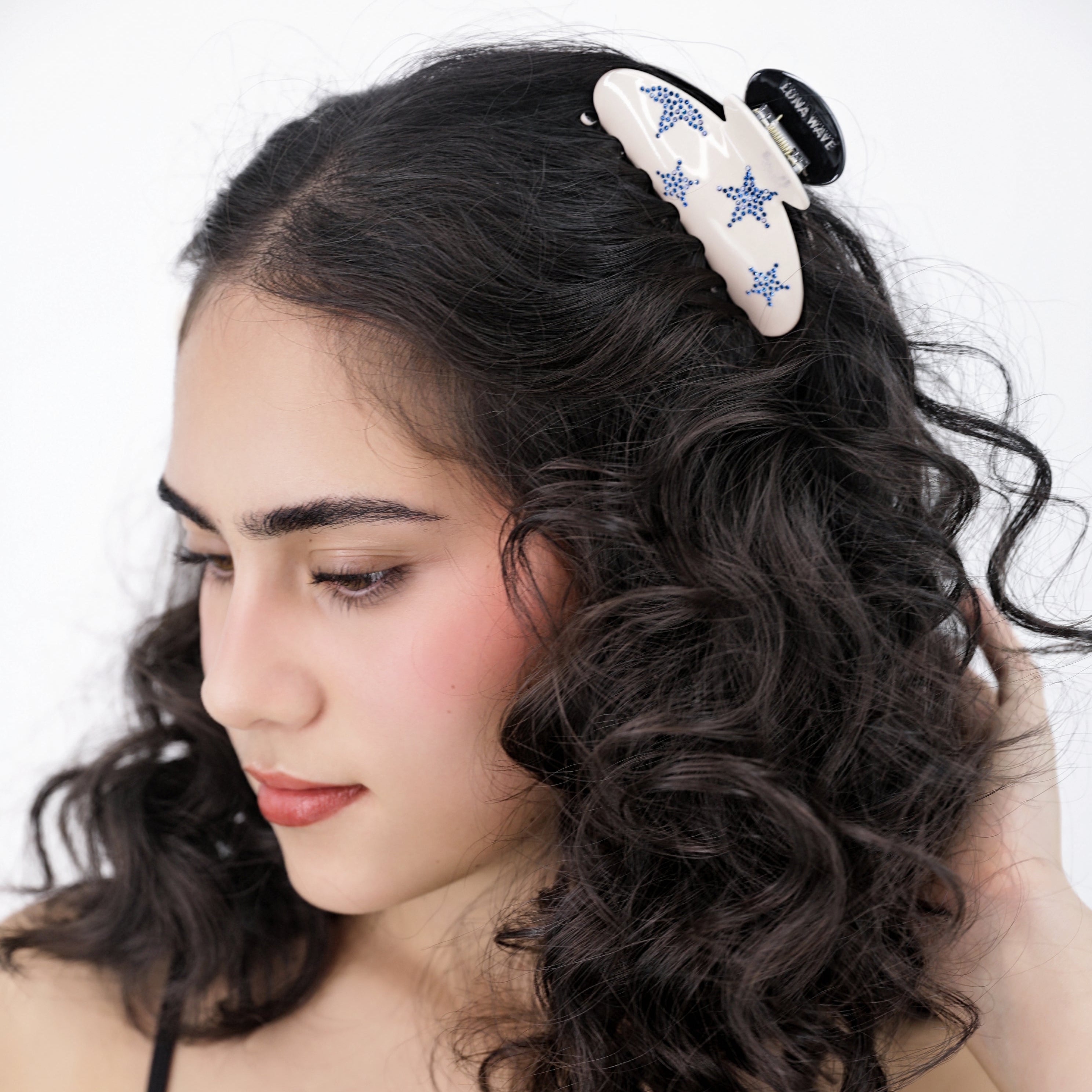 Woman with styled hair featuring a Luan Wave blue star hair claw clip against a white background