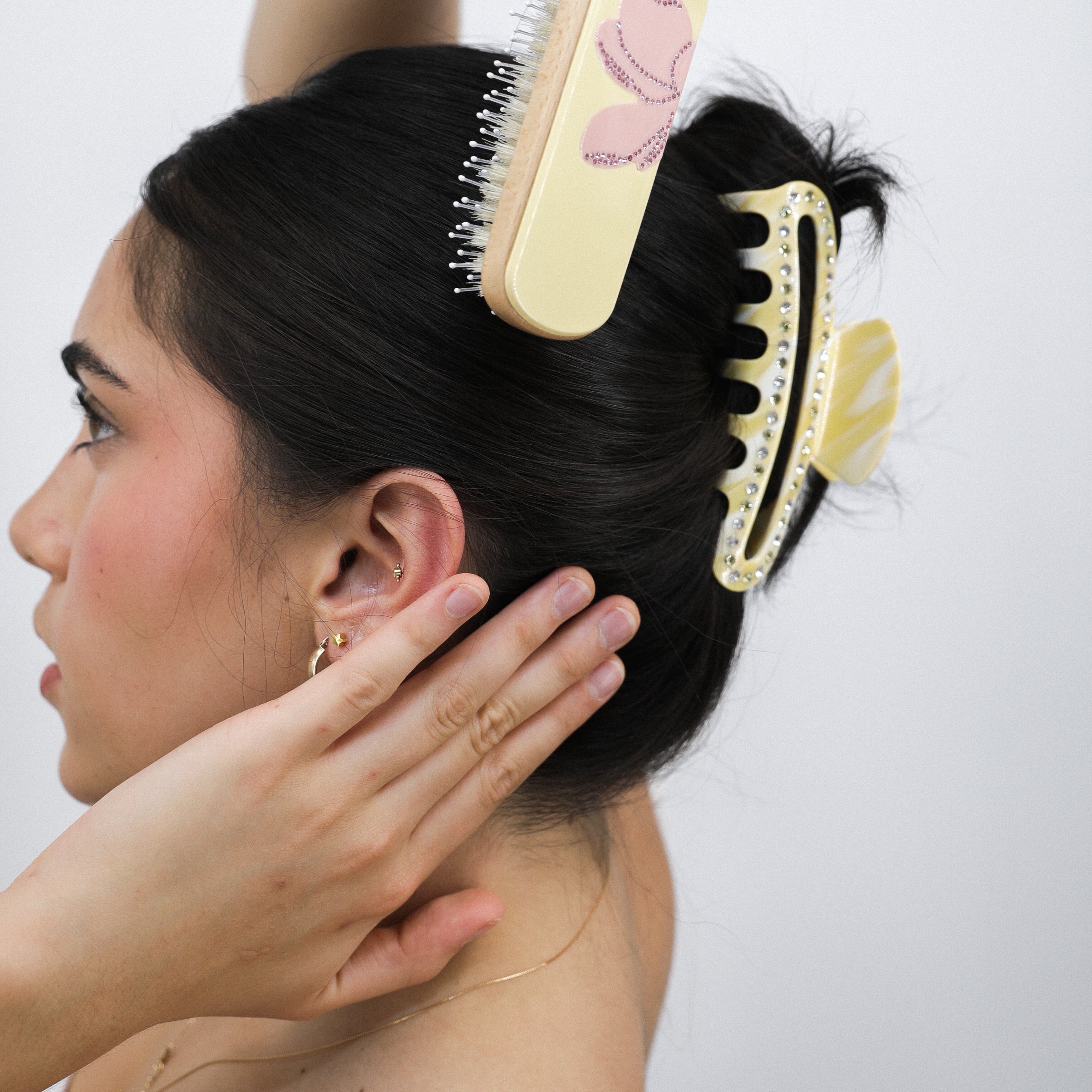Ali getting her hair styled with a Luna Wave hairbrush and Luna Wave butter cloud hair claw clip against a white background