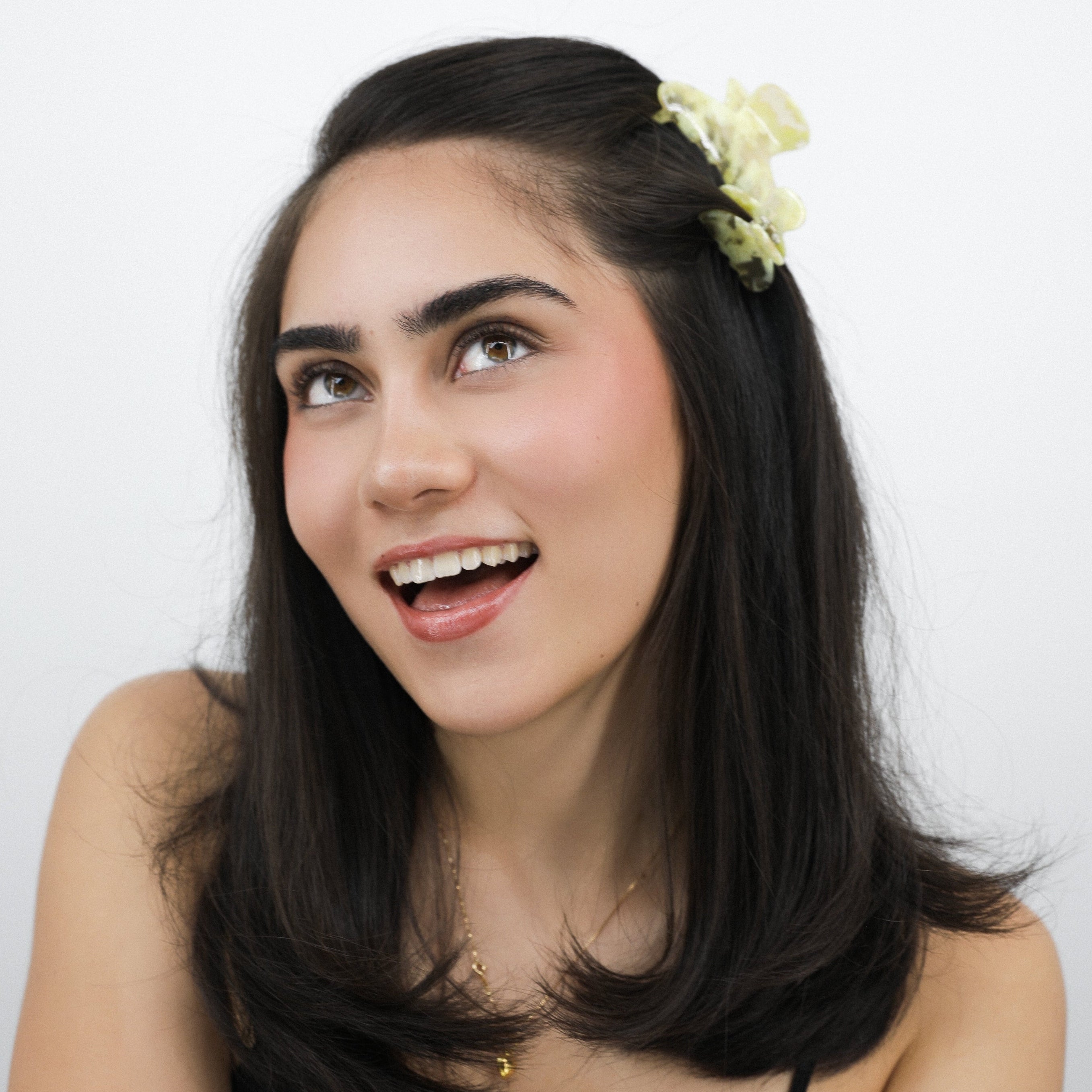 Woman with a Luna Wave yellow butter flora hair claw clip in her hair against a white background