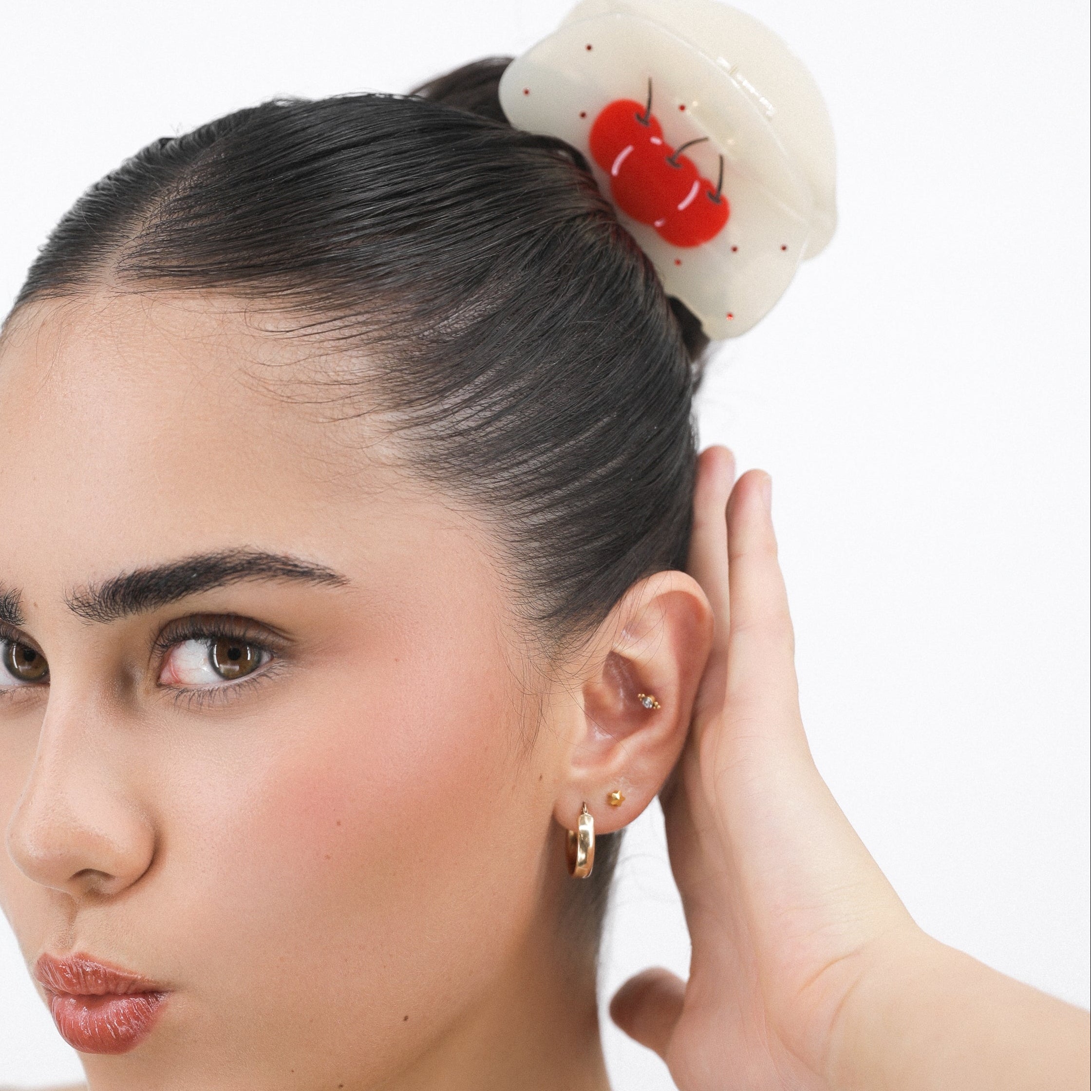 Woman with a Luna Wave red cherry crush hair claw clip against a white background