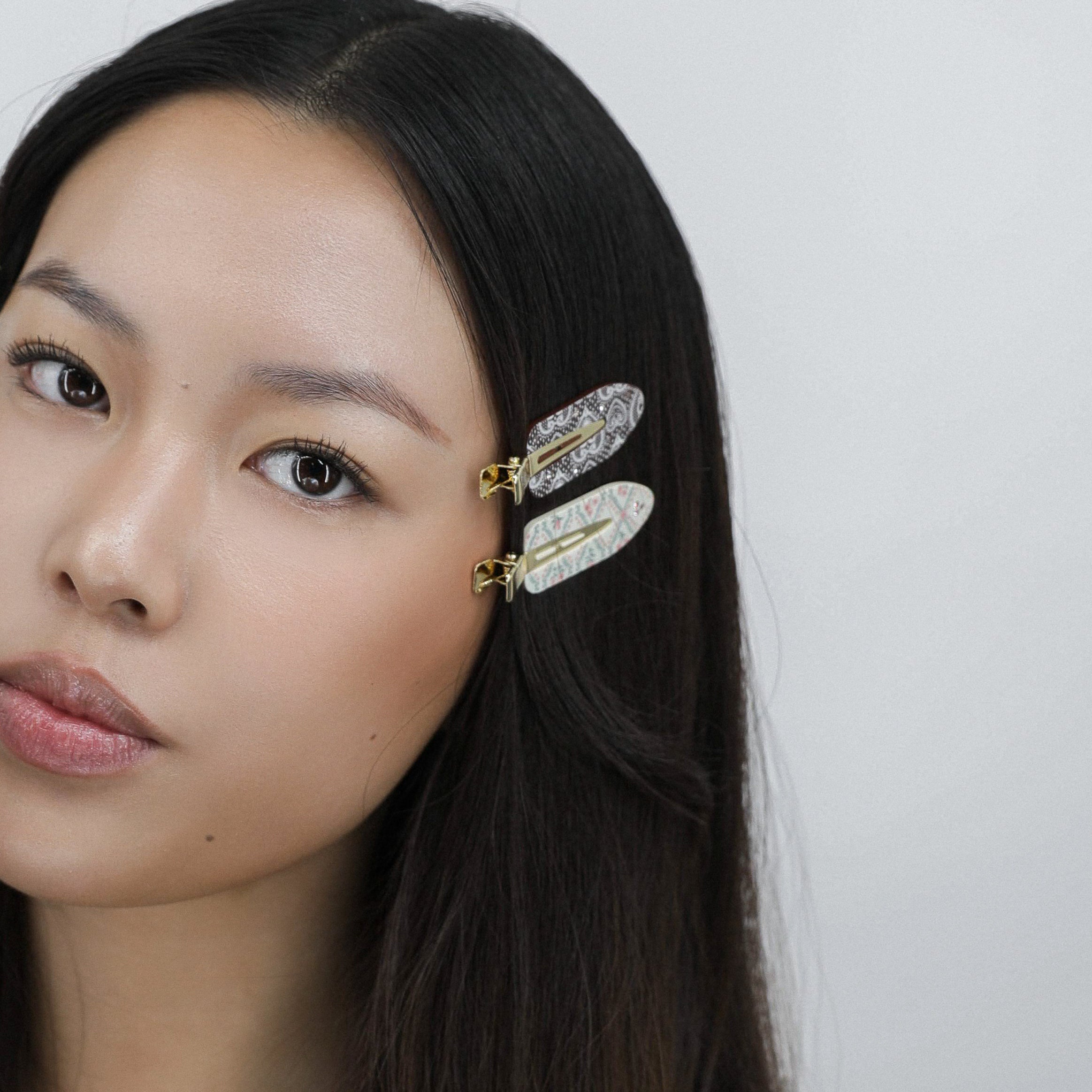 Woman with Luna Wave cocoa hair clips in her hair against a plain background