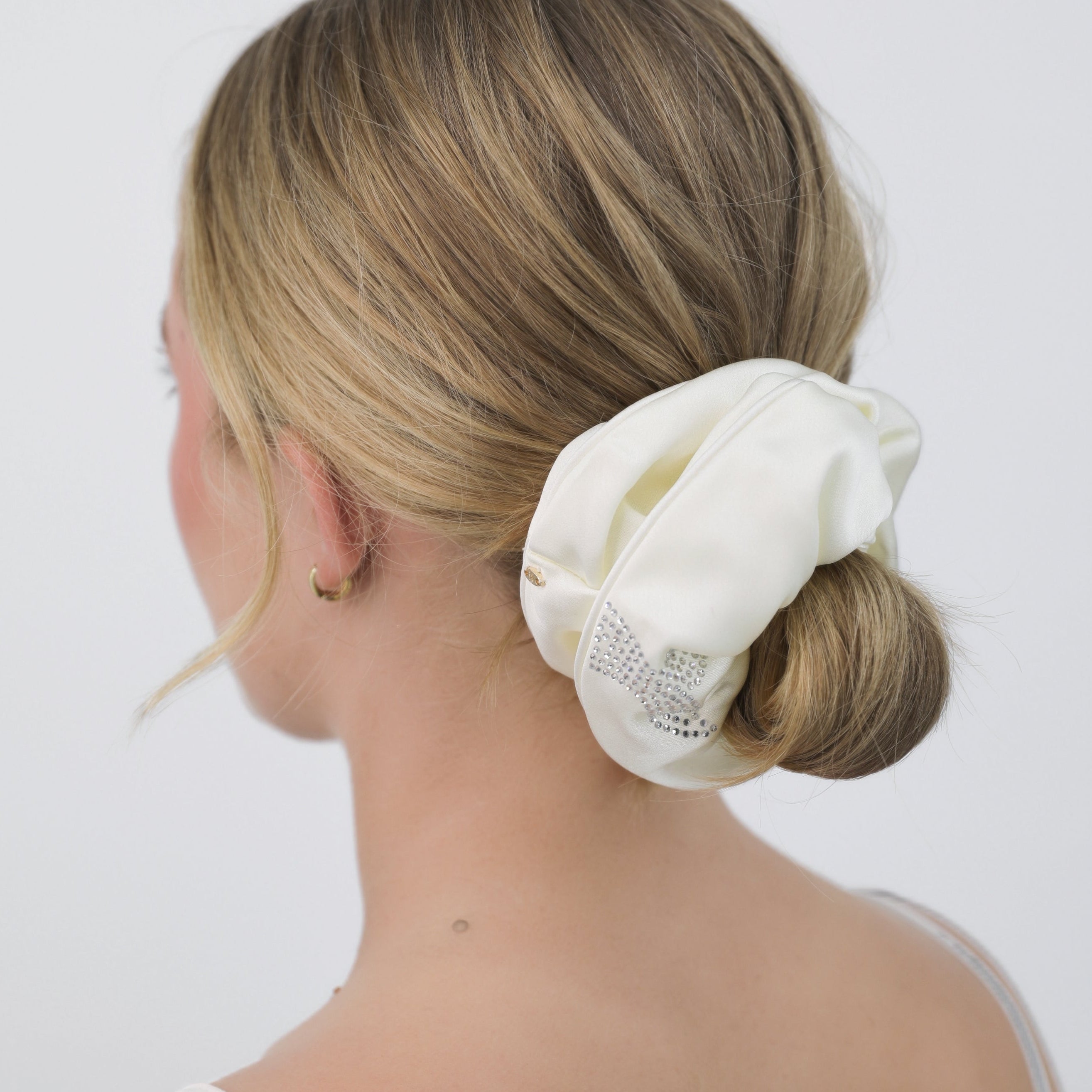 Woman with a Luna Wave white cream bubbles scrunchie on a plain background