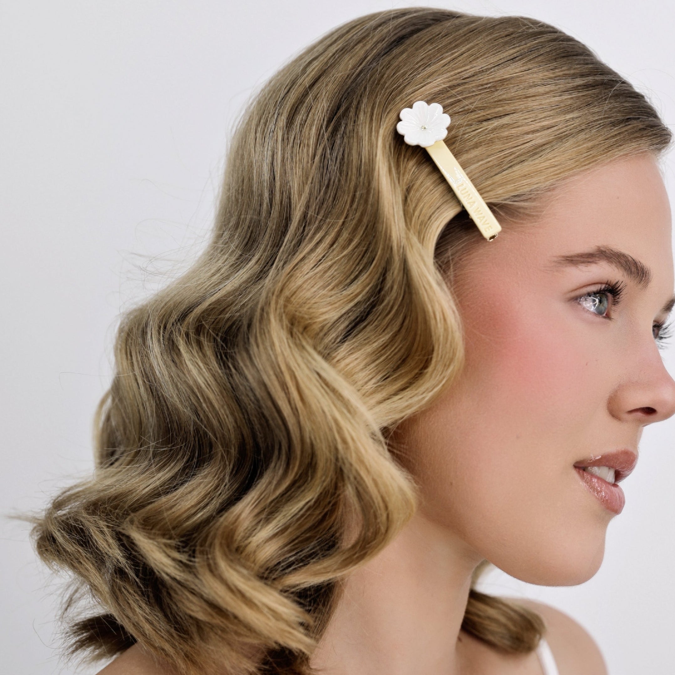 Woman with styled Luna Wave yellow daisy hair clip against a plain background