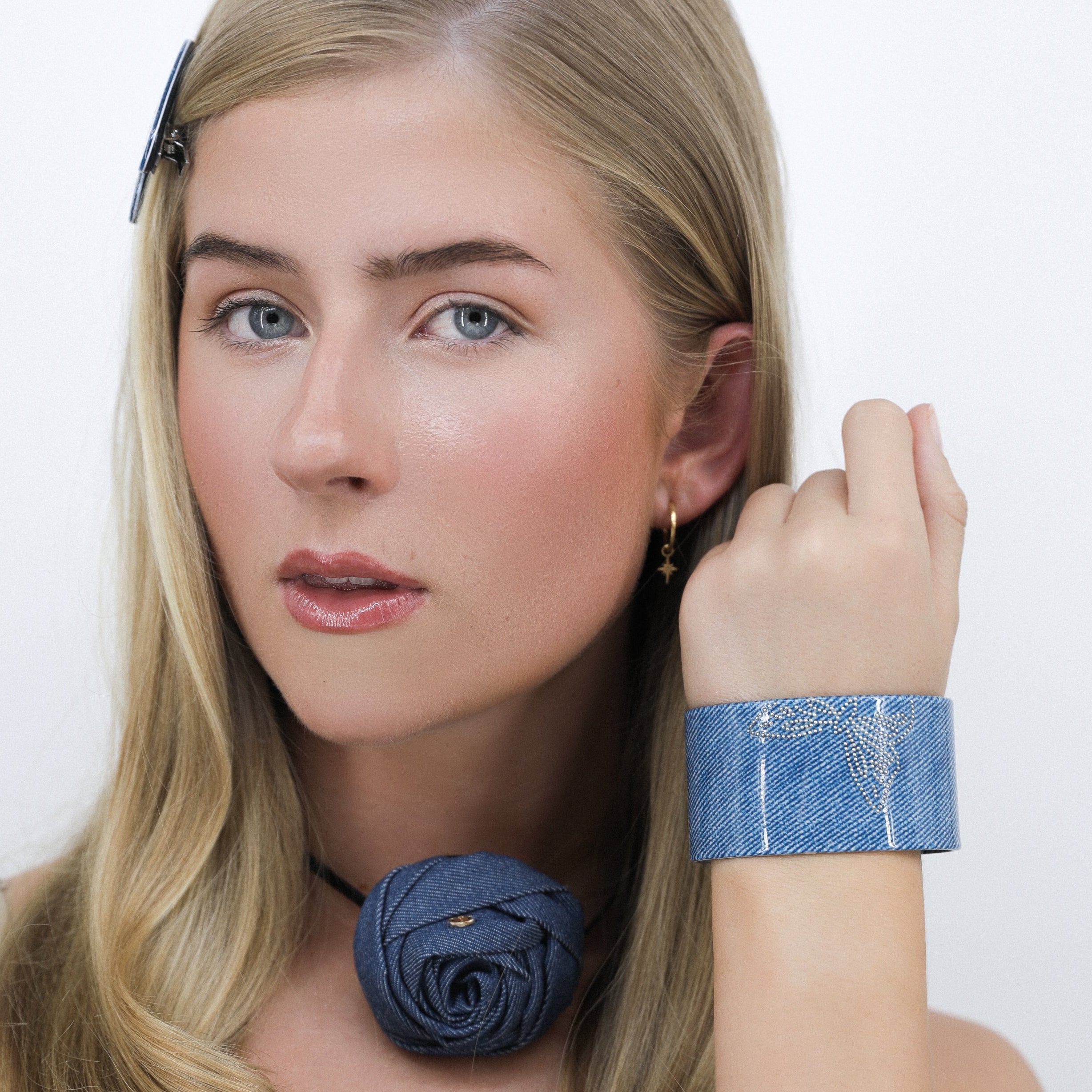 Person wearing a Luna Wave blue denim flatter bracelet against a white background