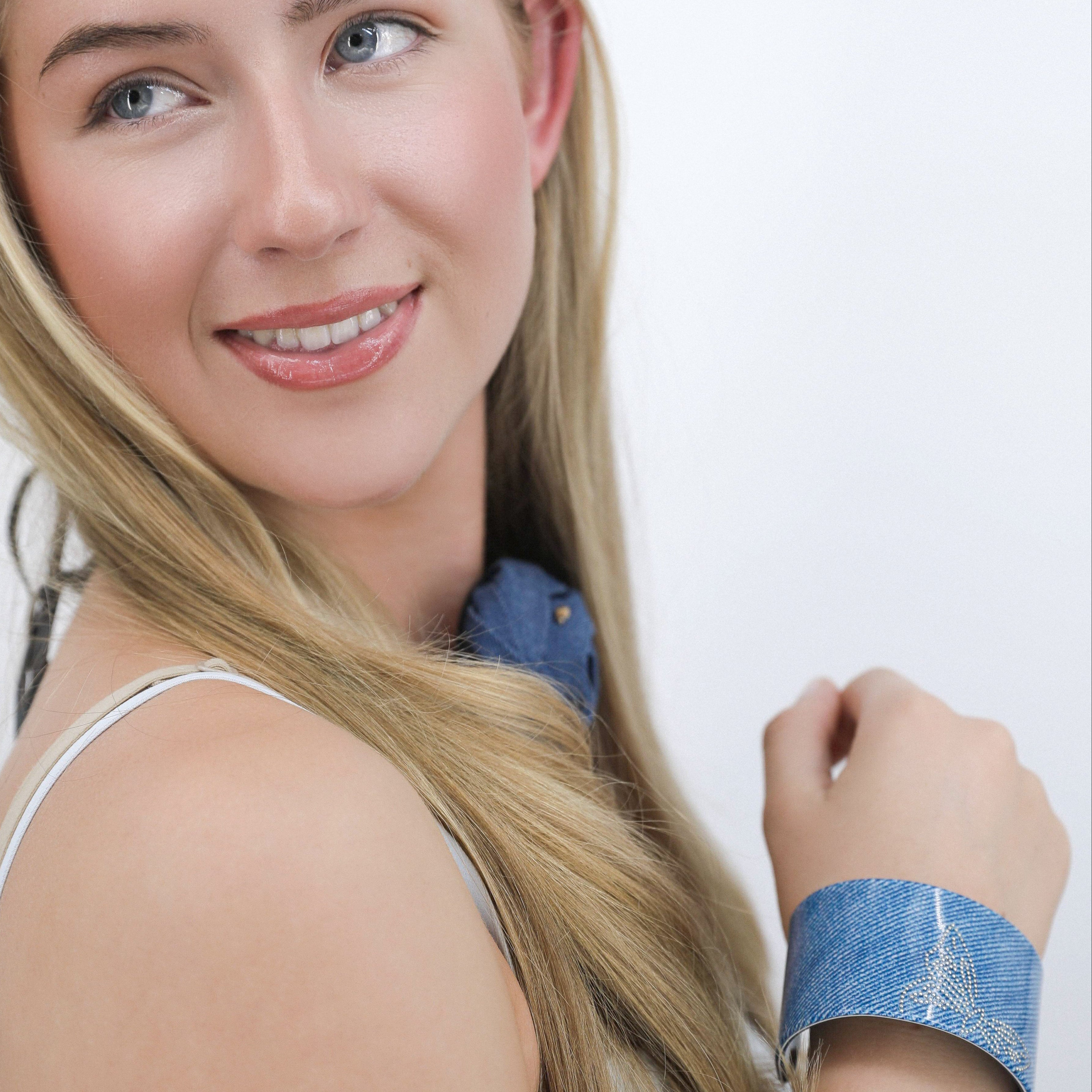 Woman with Luna Wave blue denim flatter hair clips and bracelet on a white background