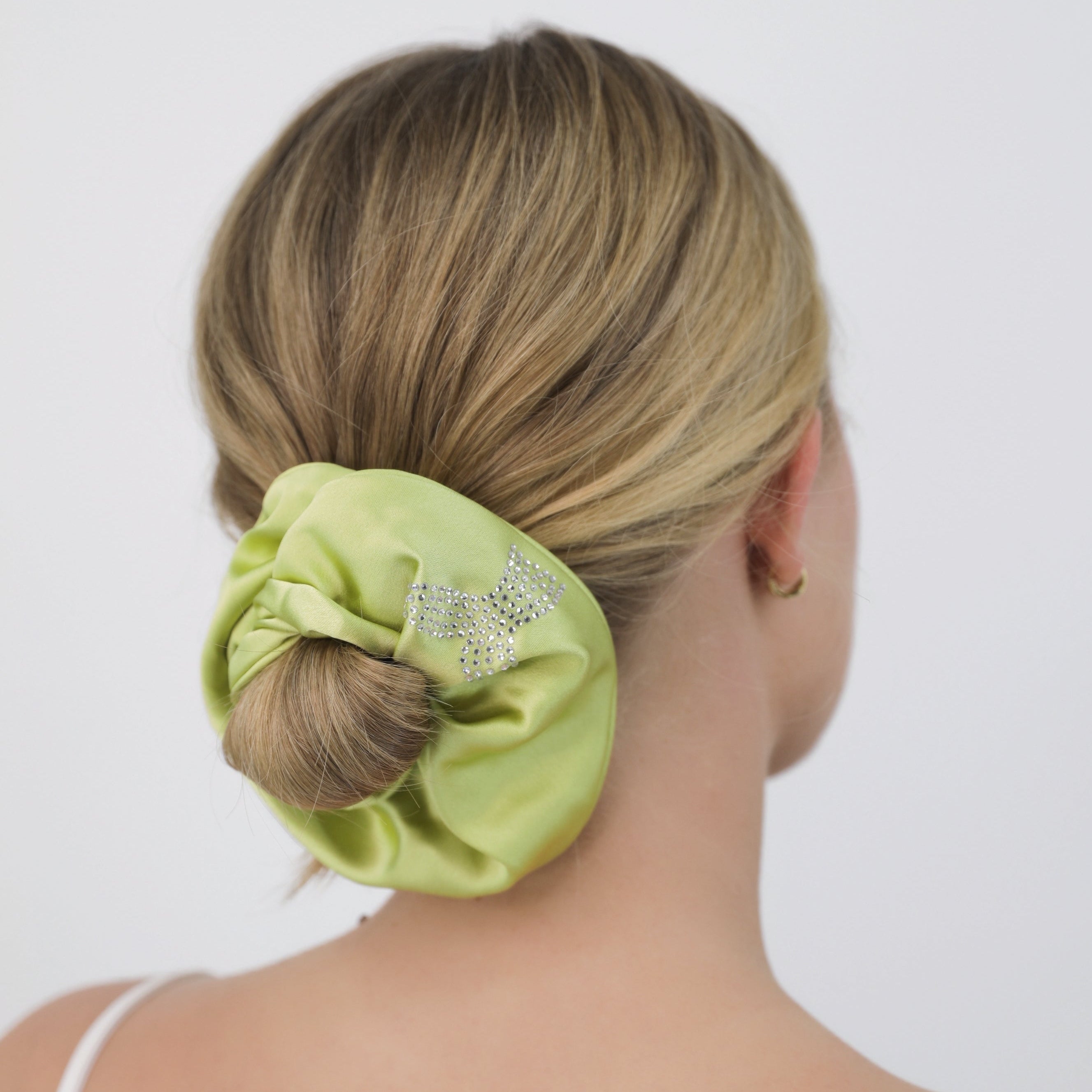 Person with a Luna Wave green bubbles scrunchie in their hair on a white background
