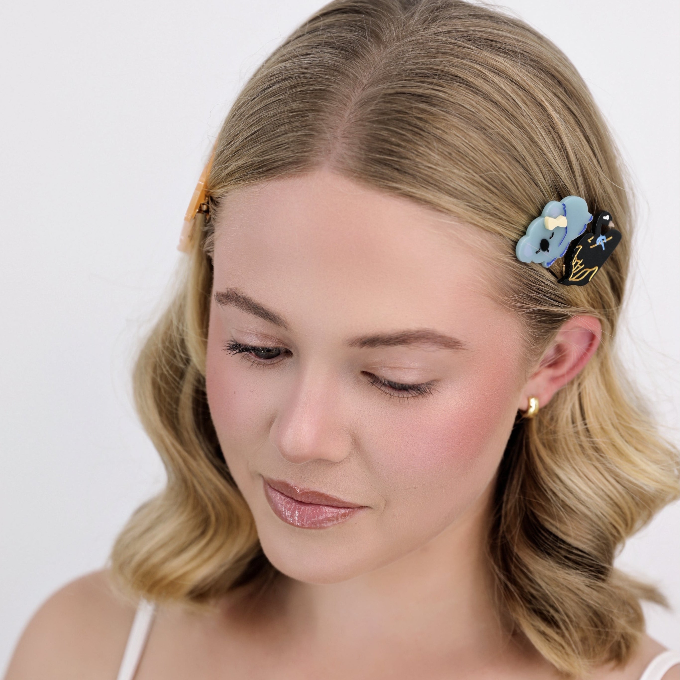 Woman with styled hair featuring Luna Wave blue koala hair clips against a white background