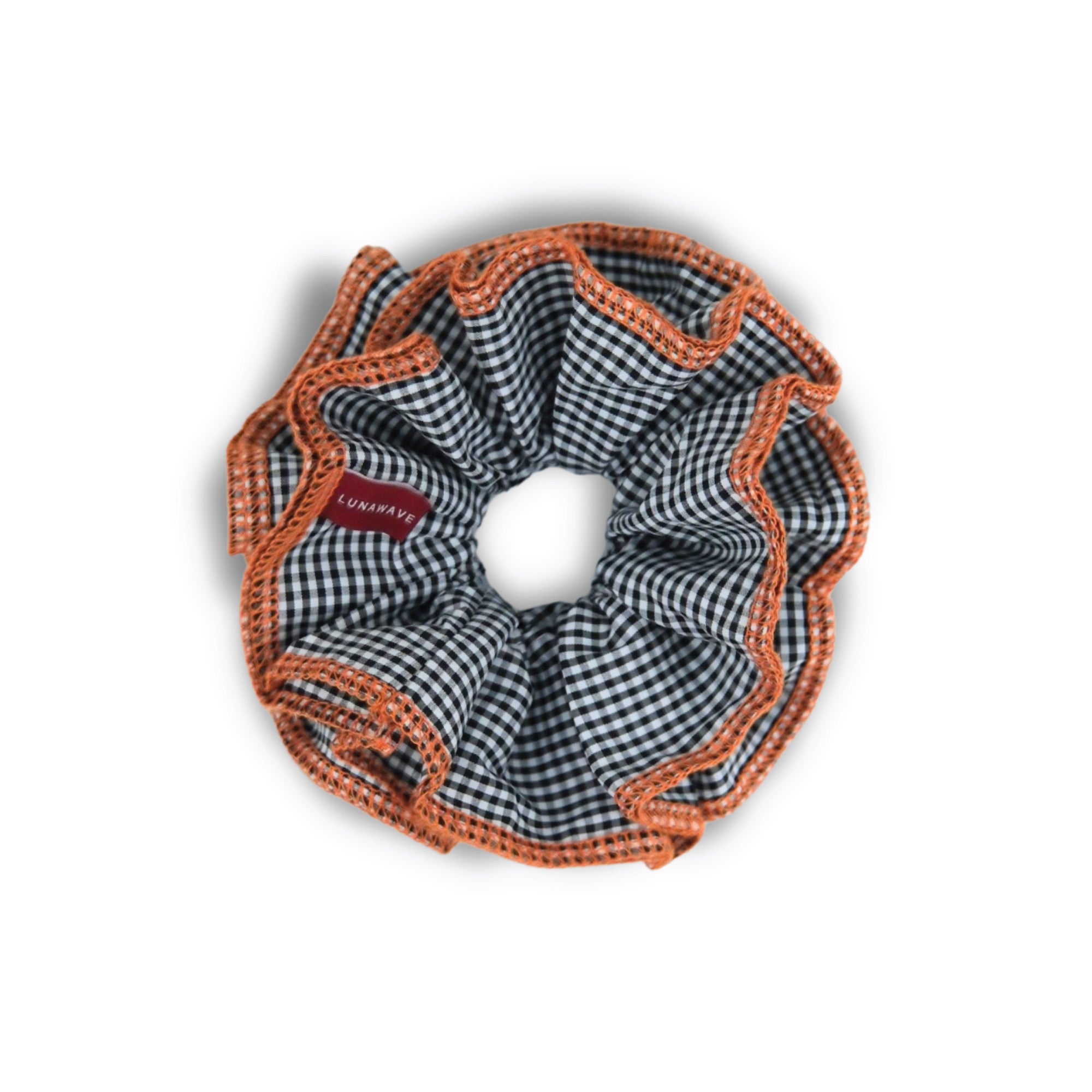 black Gingham patterned scrunchie with orange trim on a white background