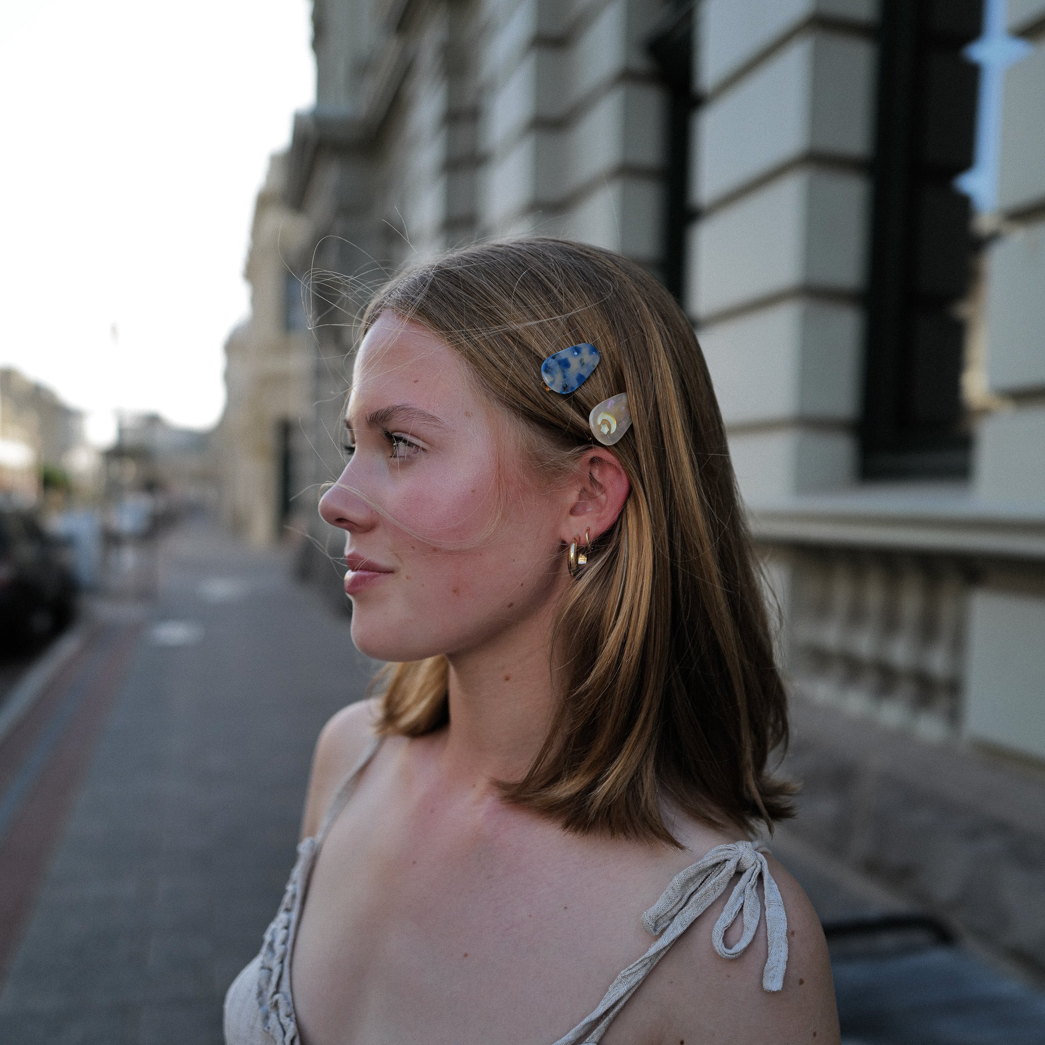 Luna Wave model with blue small hair clips standing on a street