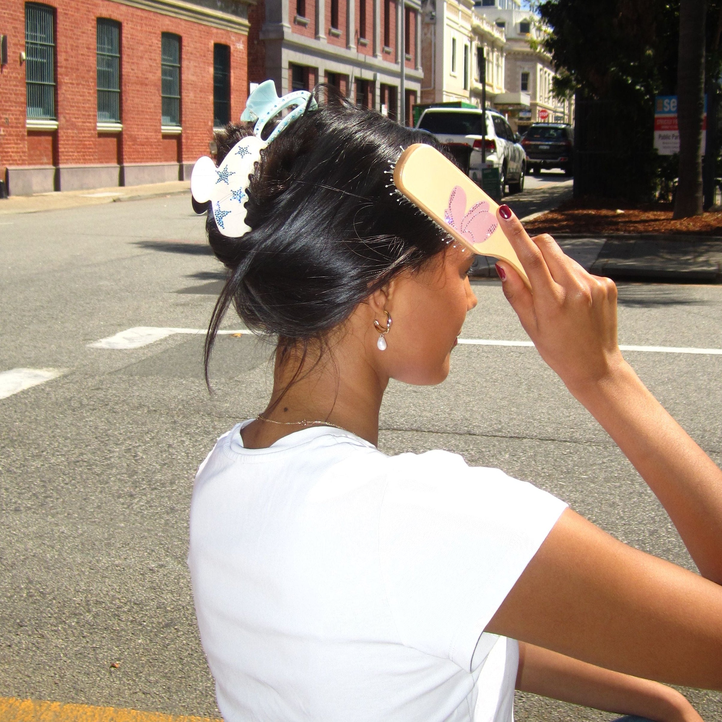 Model holding wearing Luna Wave cloud coffee collection claw clip and coralie breeze collection claw clip