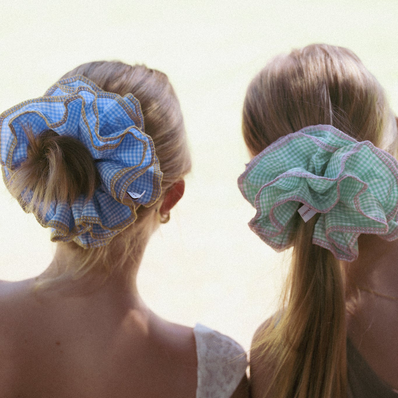 Two women with luna wavedarling-duo green scrunchies in their hair