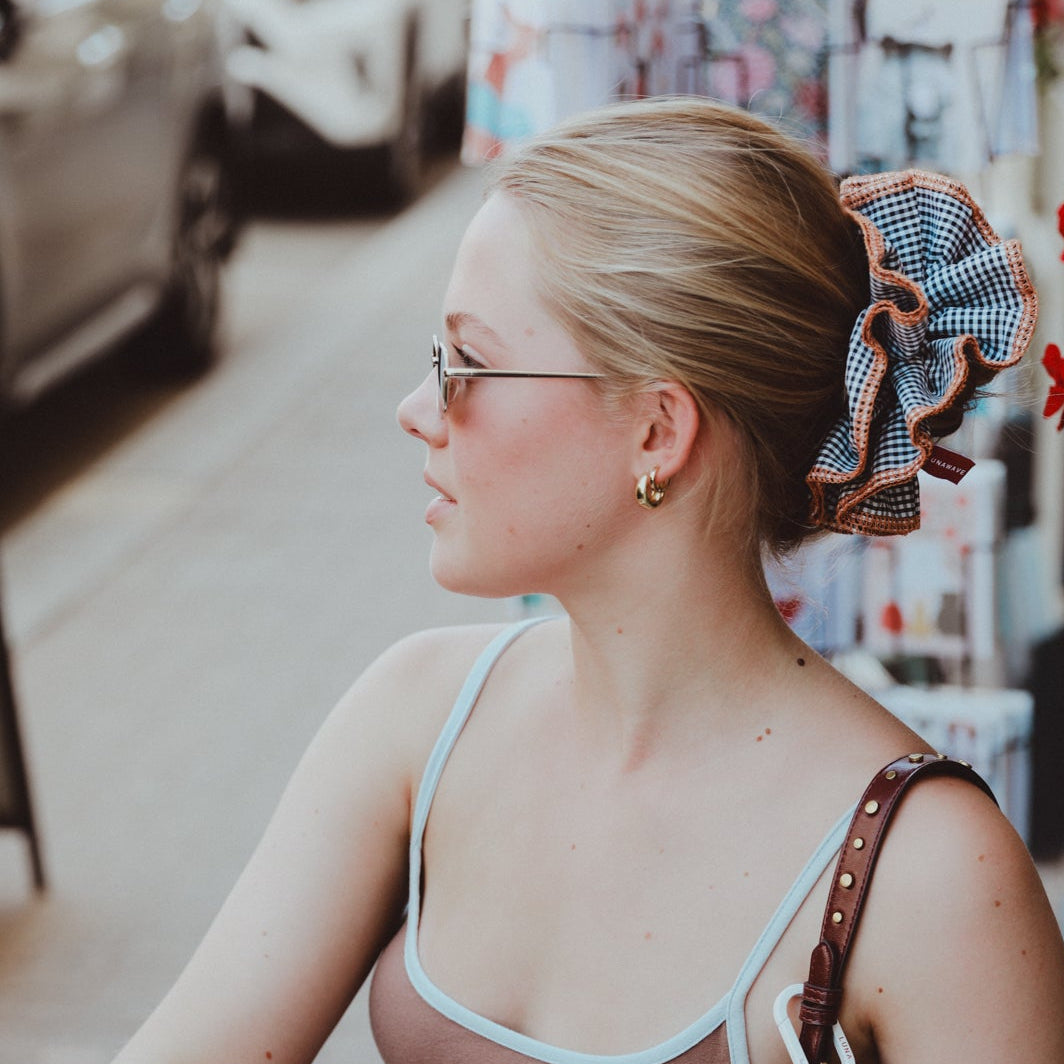 Woman reading a book in a store with flowers and products in the background