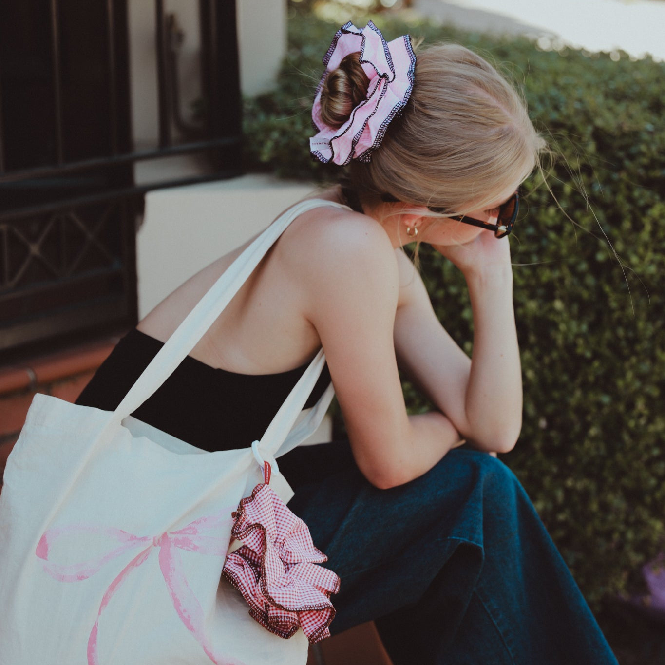 luna wave model sitting outdoors with a darling duo pink scrunchie.
