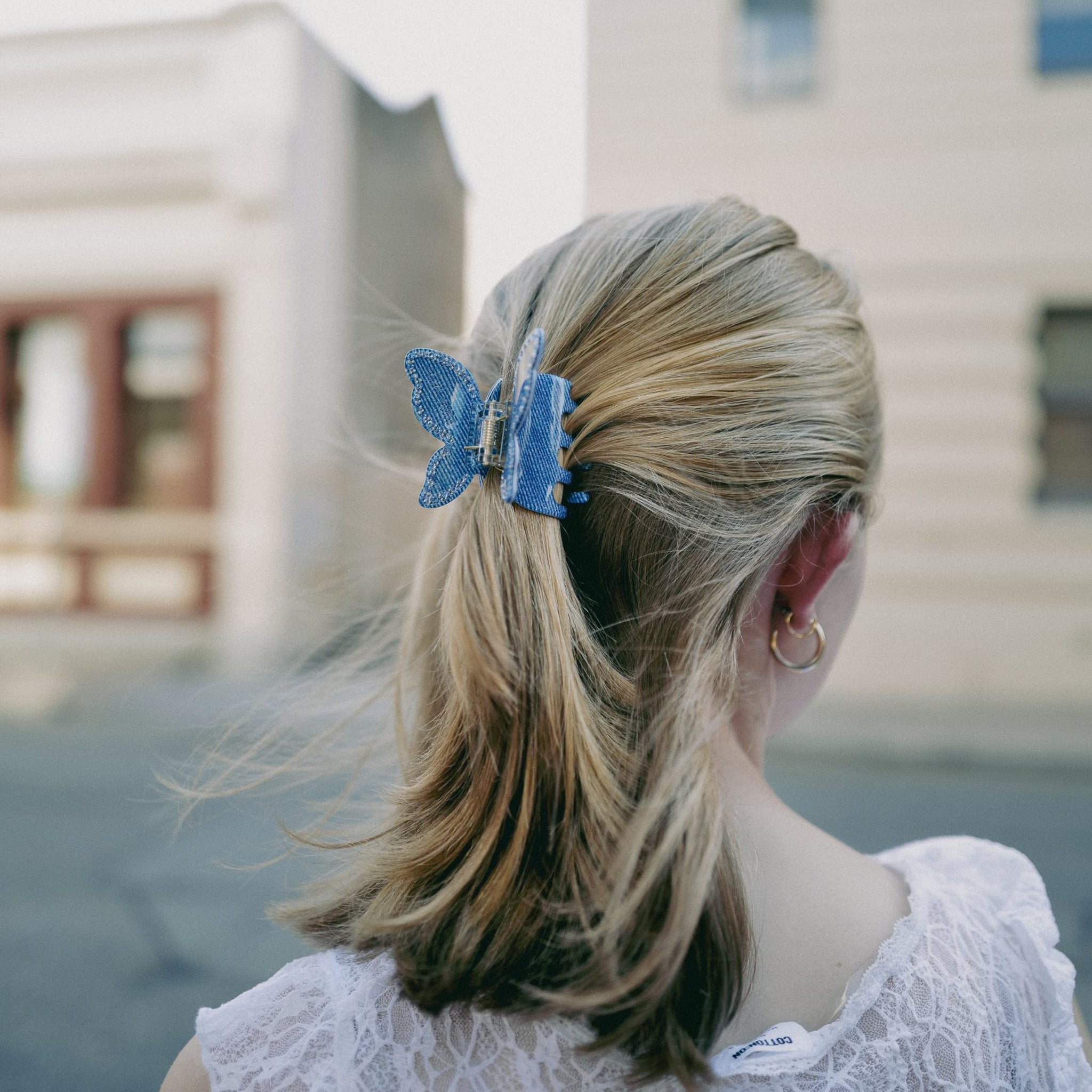 Luna Wave Model with blue denim butterfly hair clip in outdoor setting
