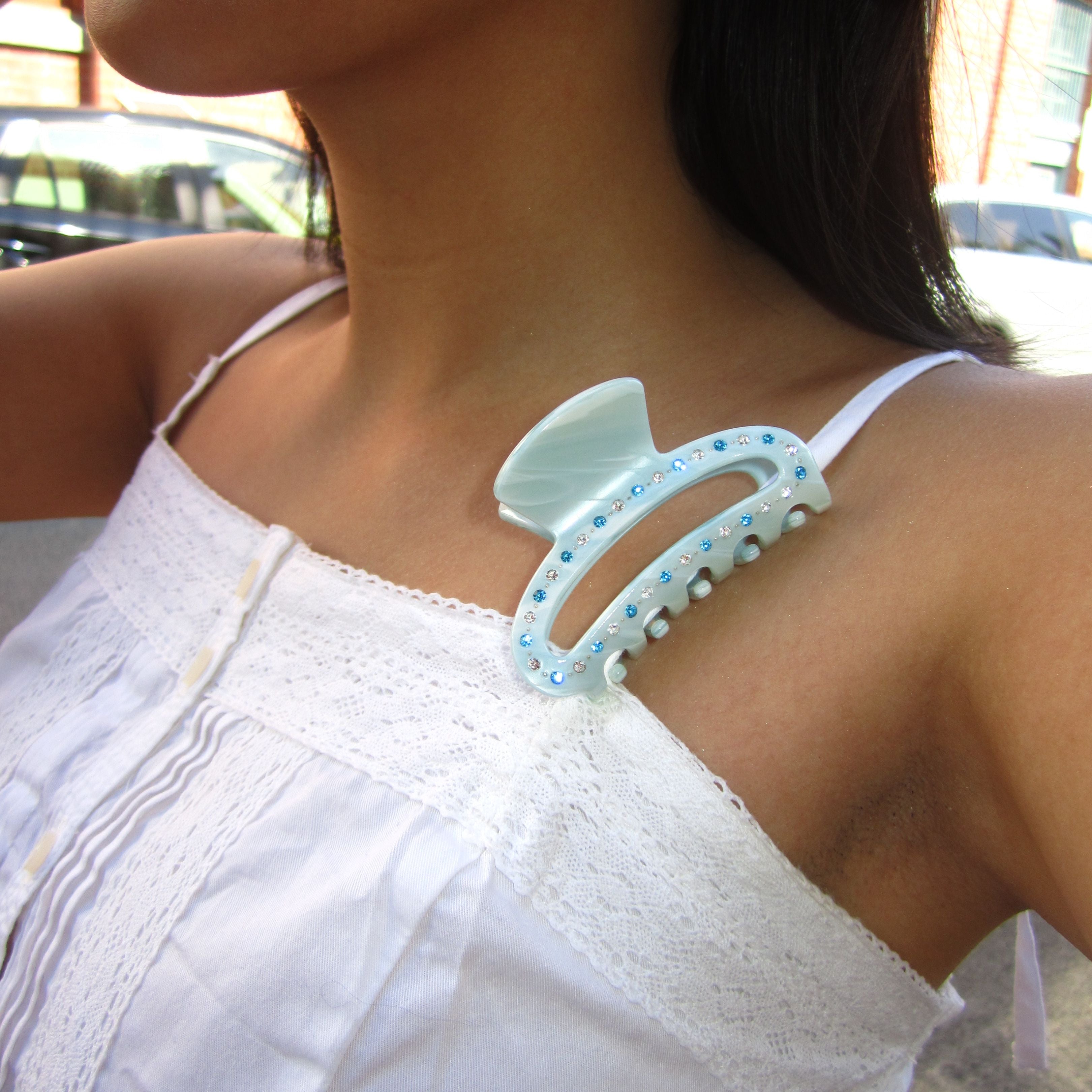 Woman wearing a Luna Wave ice cloud midi claw on her white top