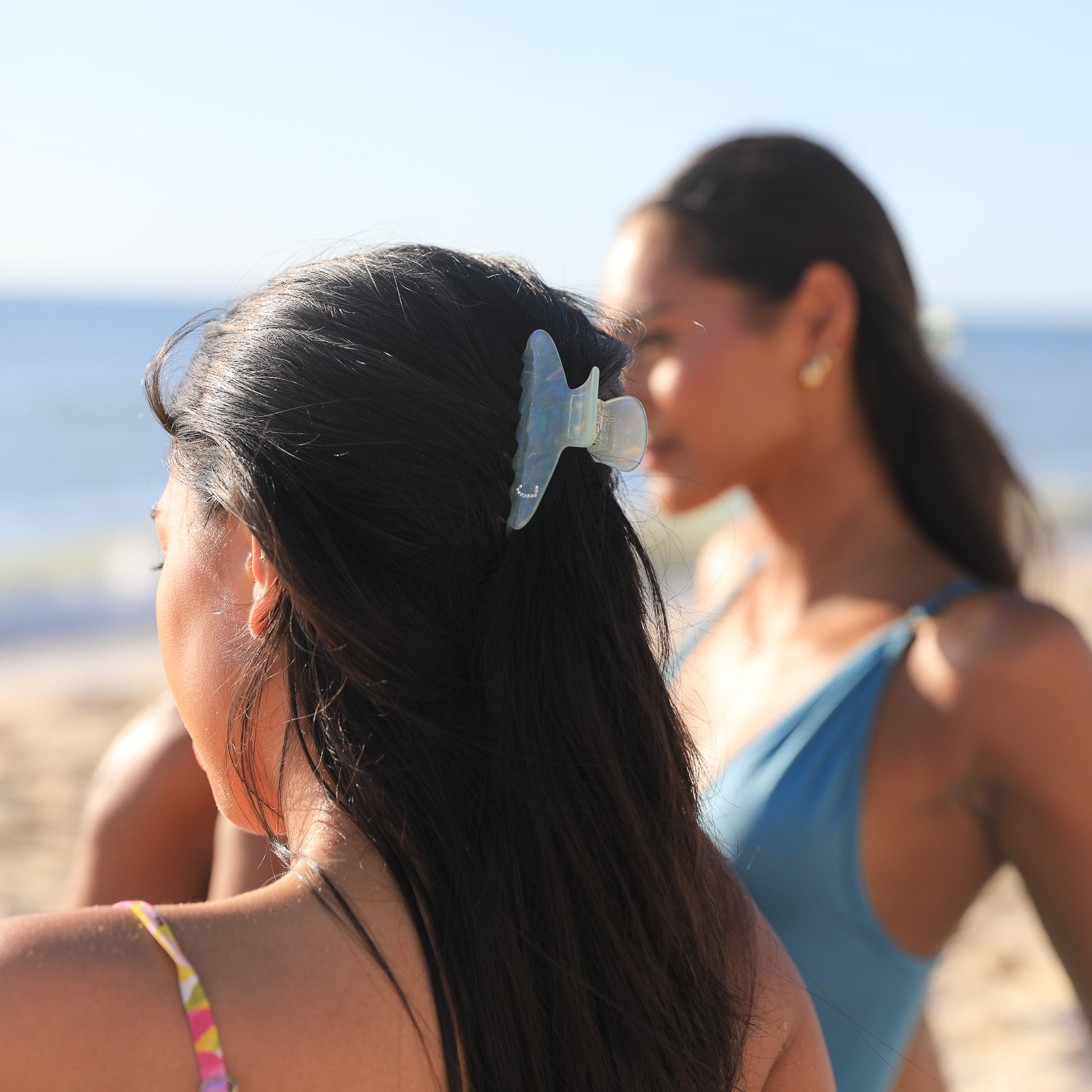 Two Luna Wave model on a beach with initial hair clip.