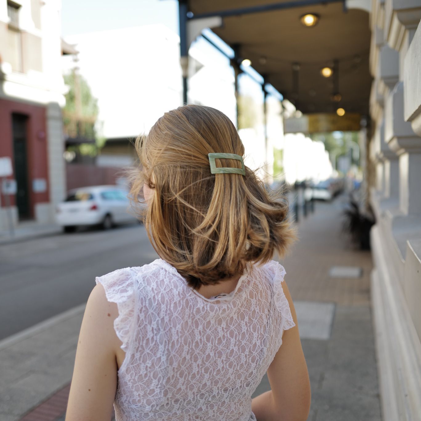 Luna wave model with a green jade earth hair barrette on a city street.