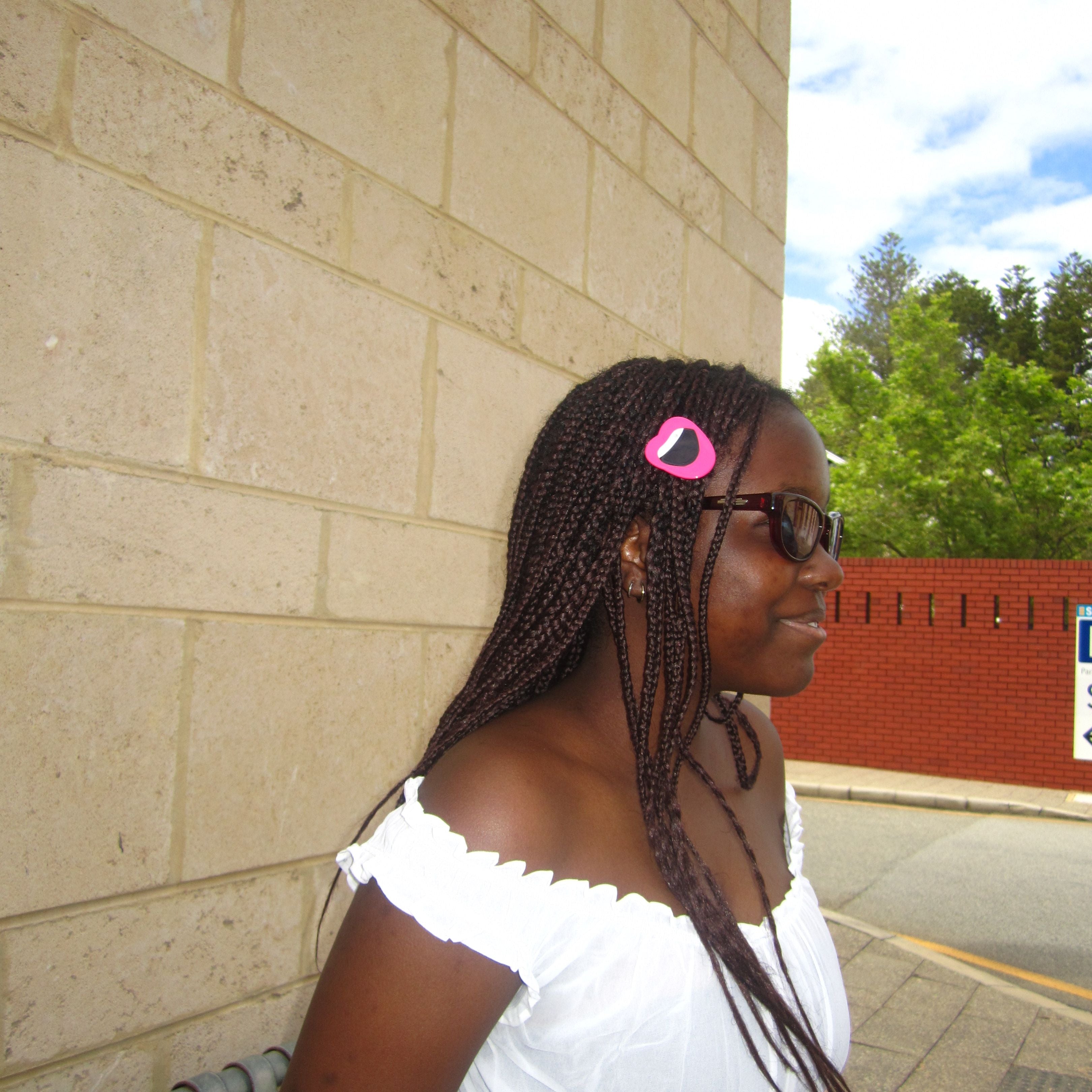 Model wearing Luna Wave drunk in love collection lip hair clip on her hair and taking a photo on the street