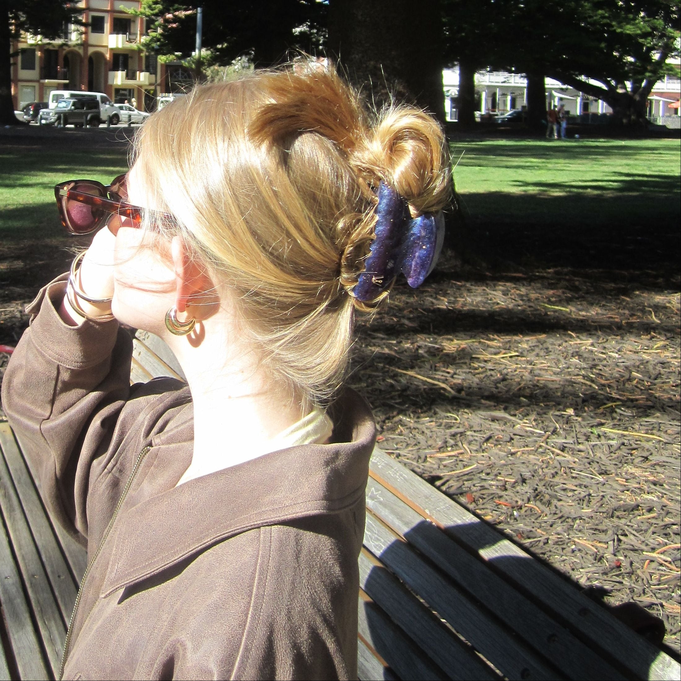 Person sitting under the tree wearing Luna Wave coffee cloud collection midnight galaxy claw