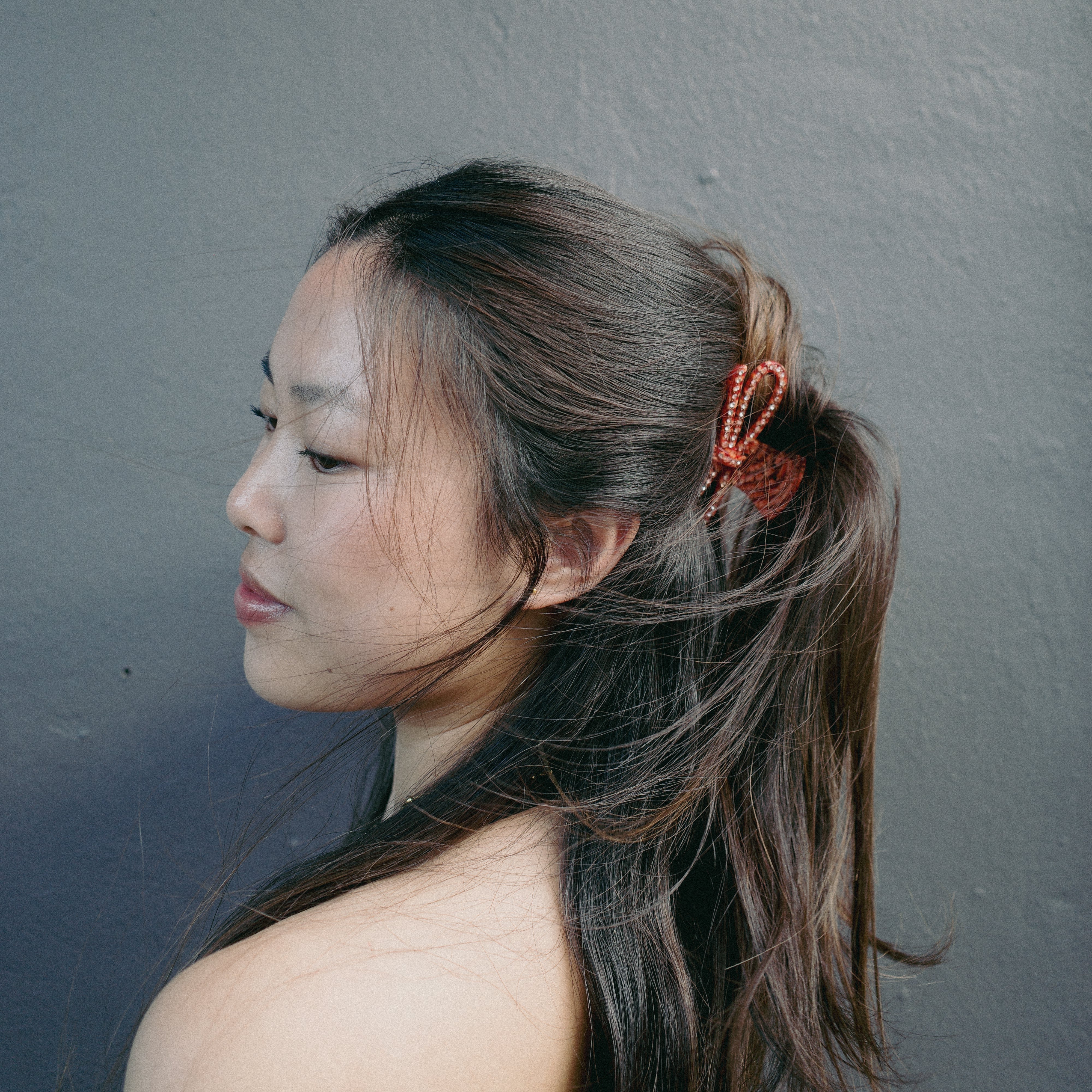 Luna Wave model with a red bow crystal claw clip standing 