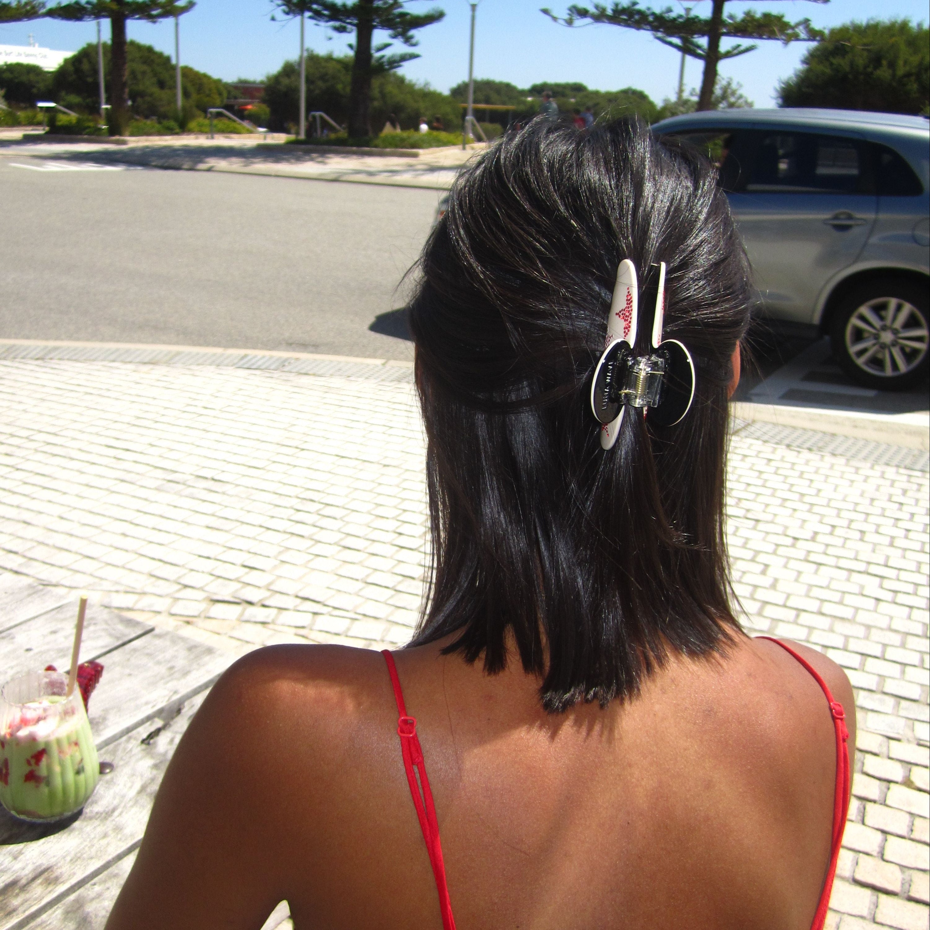 Lady with Luna Wave red start claw clip  in on a sunny day 