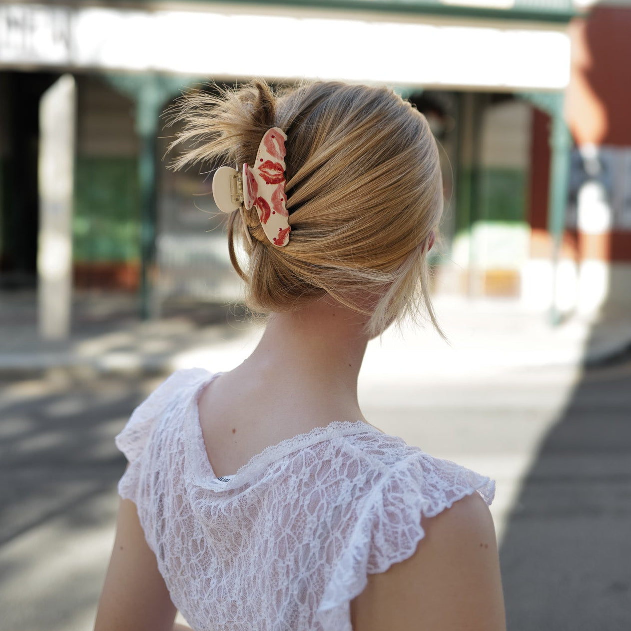 Luna wave model with a rosy hair claw clip in their bun.