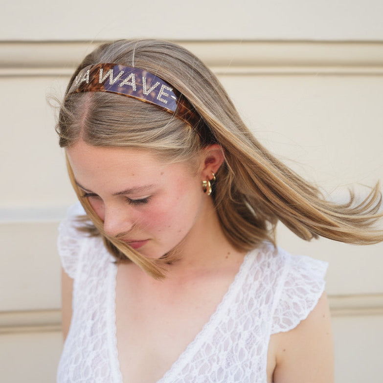 Lady wearing a headband with 'LUNA WAVE' signature
