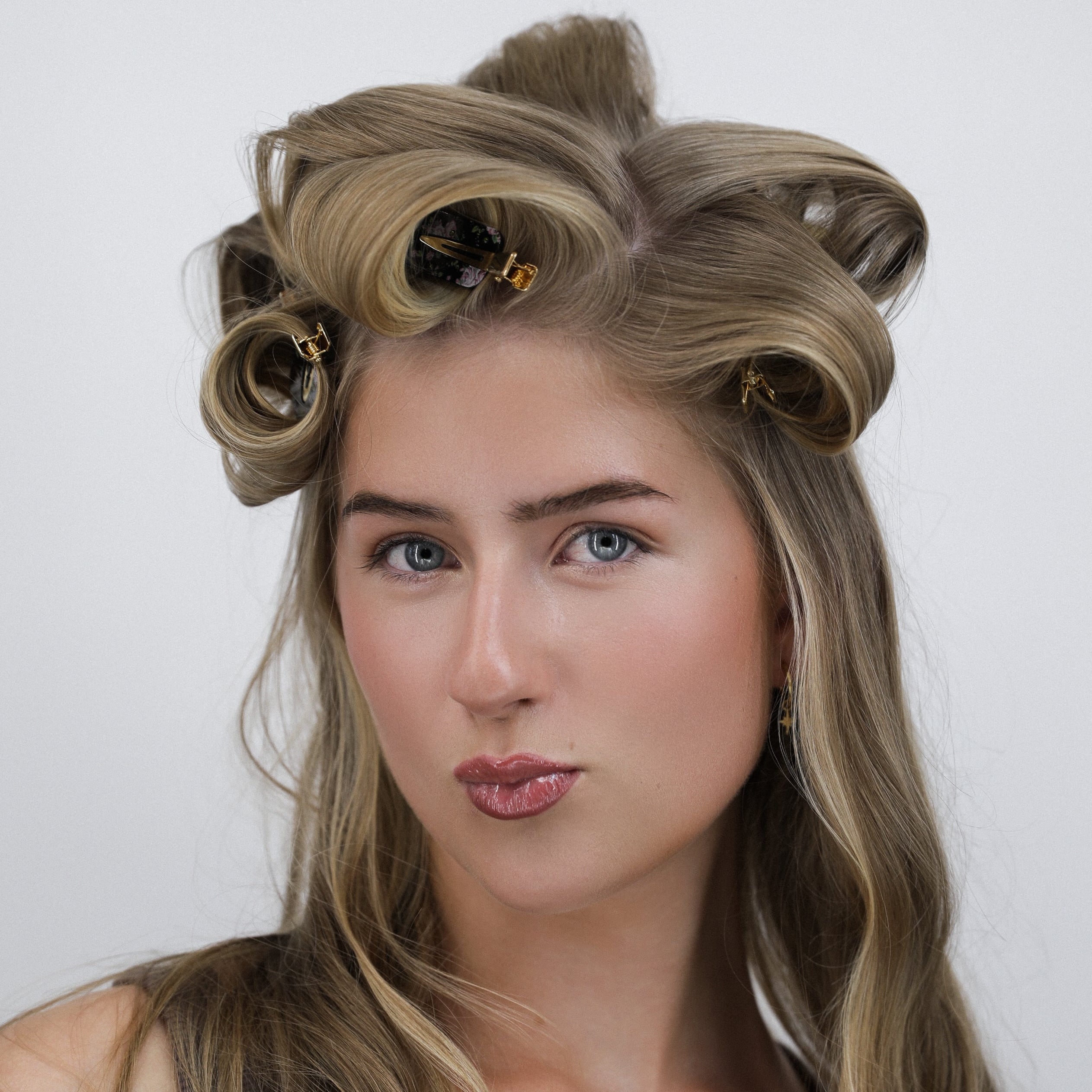 Woman with Luna Wave black midnight garden hair clips in rollers against a plain background