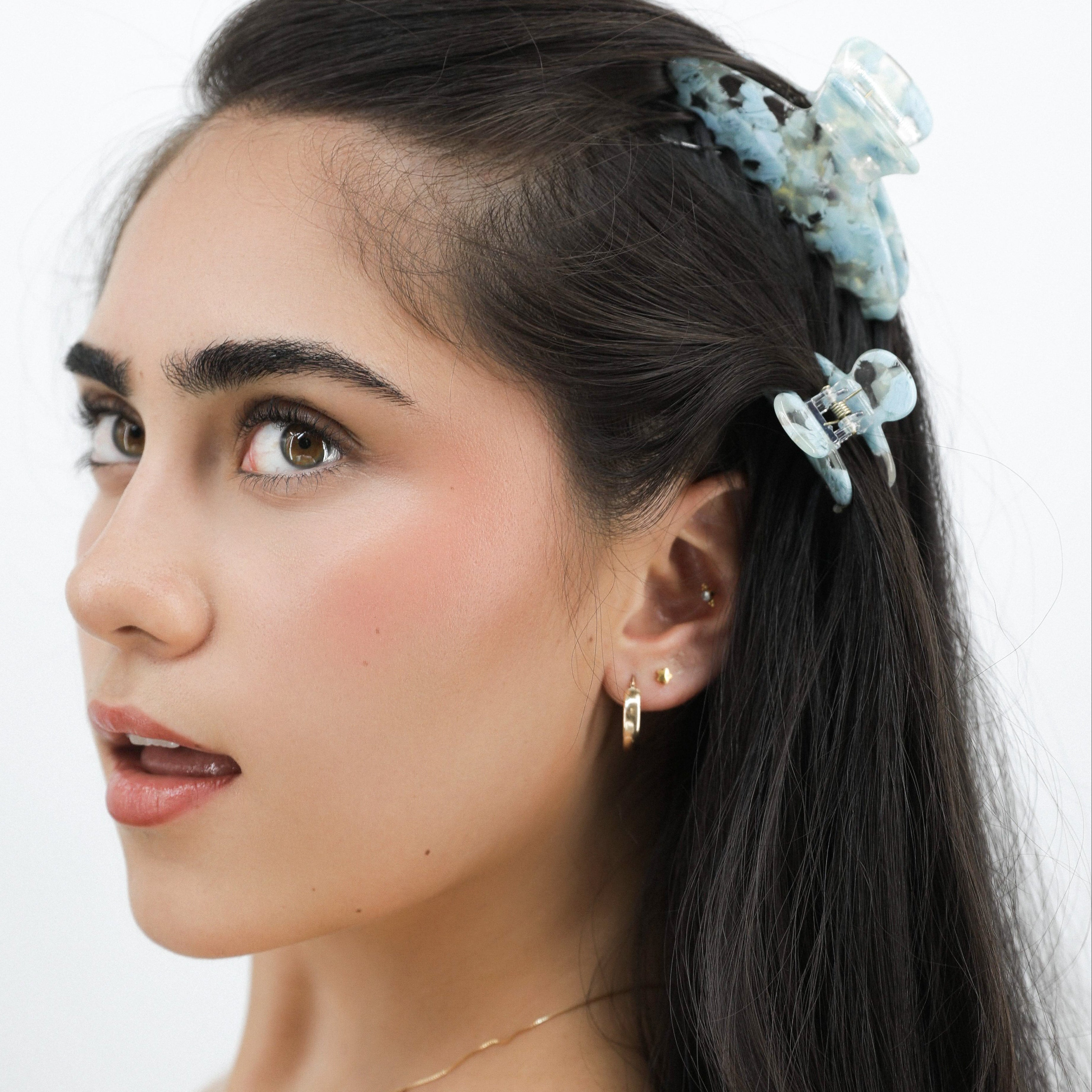 Lady with a Luna Wave blue mist floral hair claw clip and veil on a white background