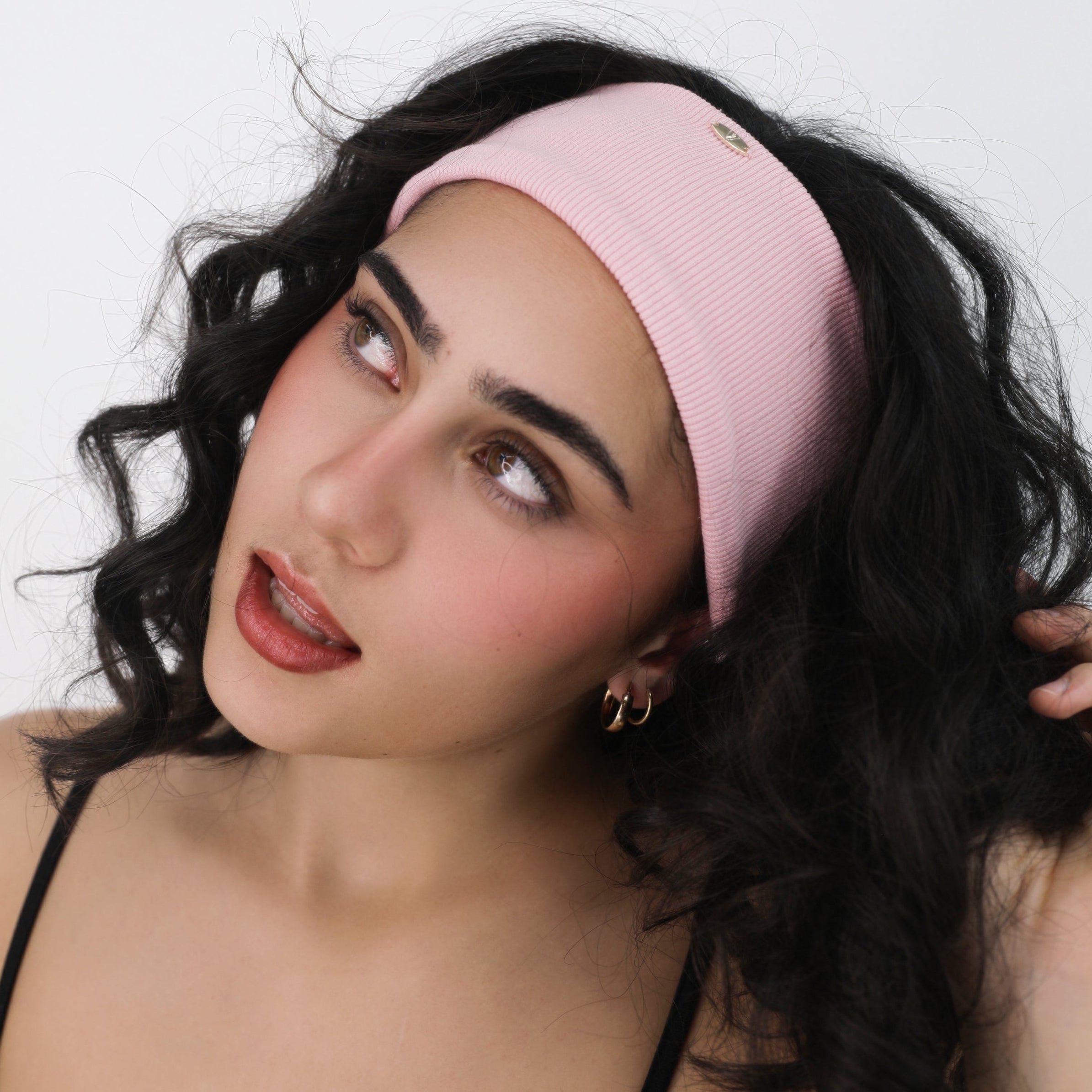 Woman wearing a Luna Wave pink coral soft hair headband against a white background