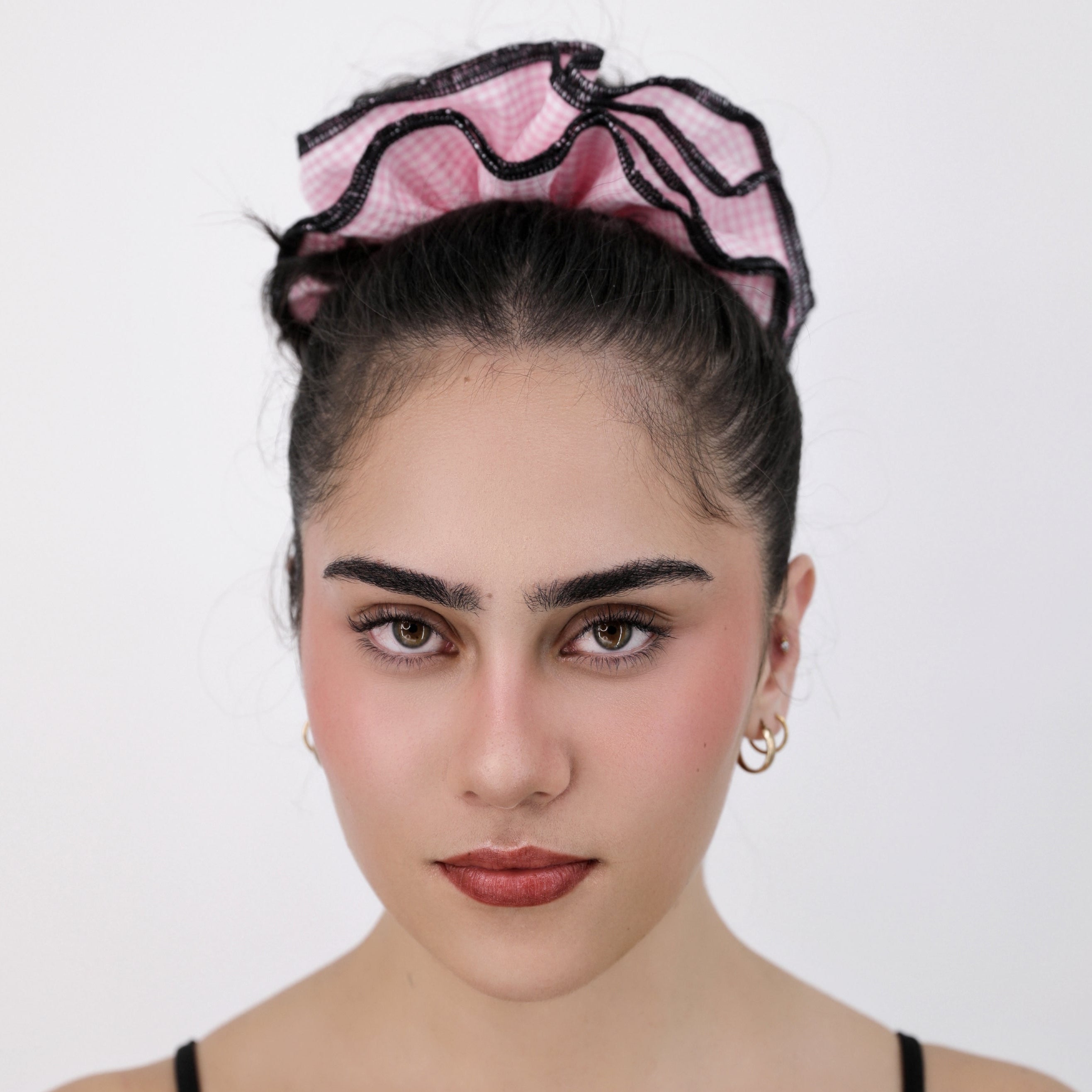 Woman with a Luna Wave pink check scrunchie against a white background