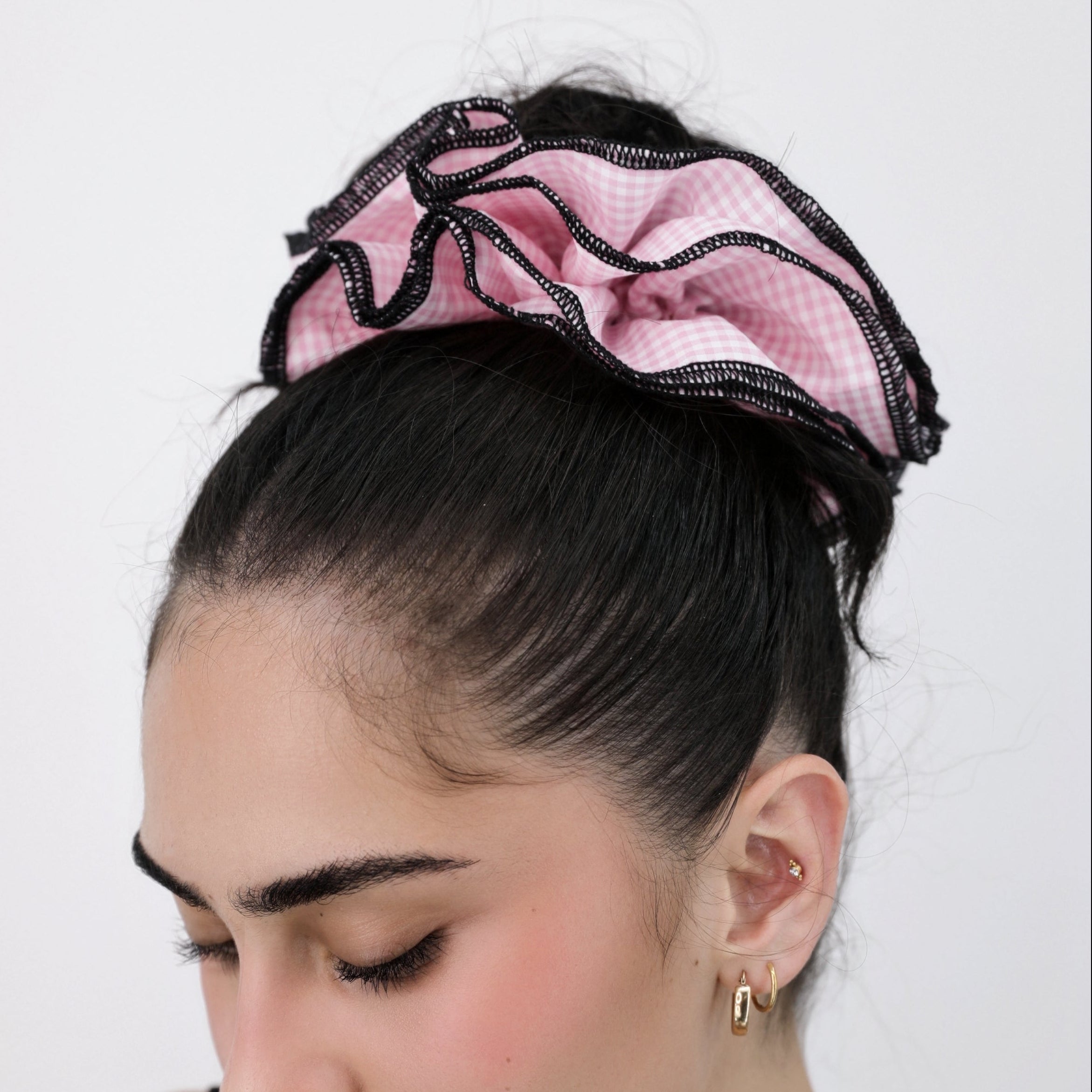 Woman wearing a Luna Wave pink check hair scrunchie on a white background