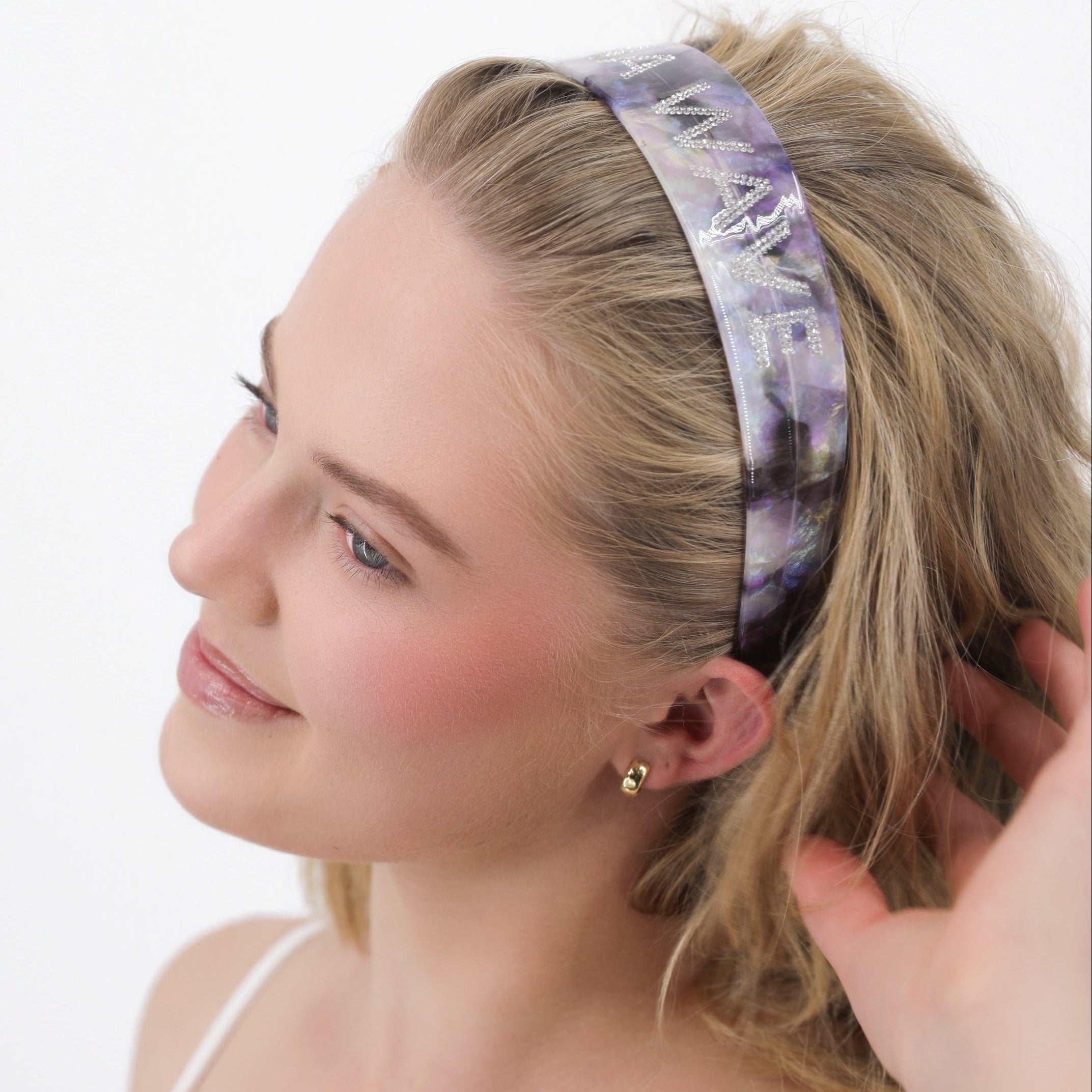 Woman wearing a purple violet signature headband on a white background