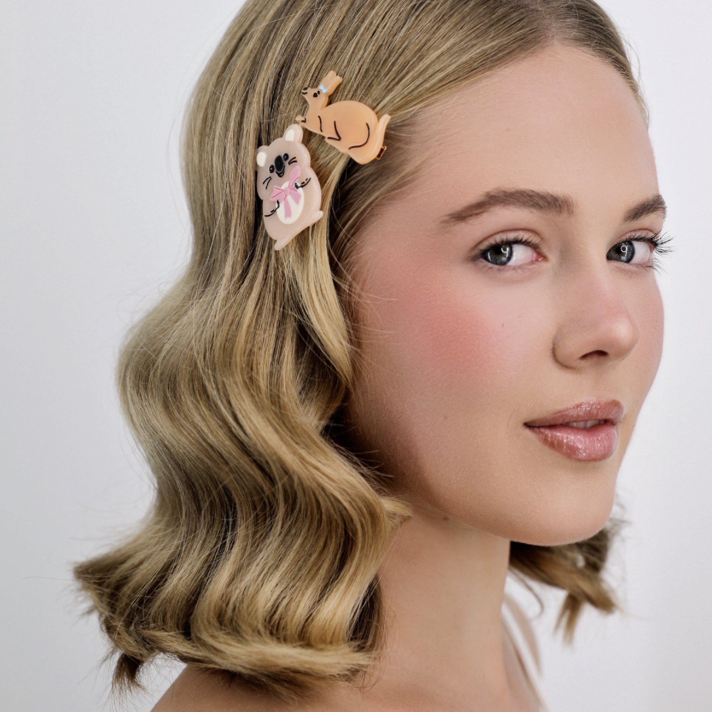 Woman with styled hair featuring a Luna Wave quokka hair clip against a plain background