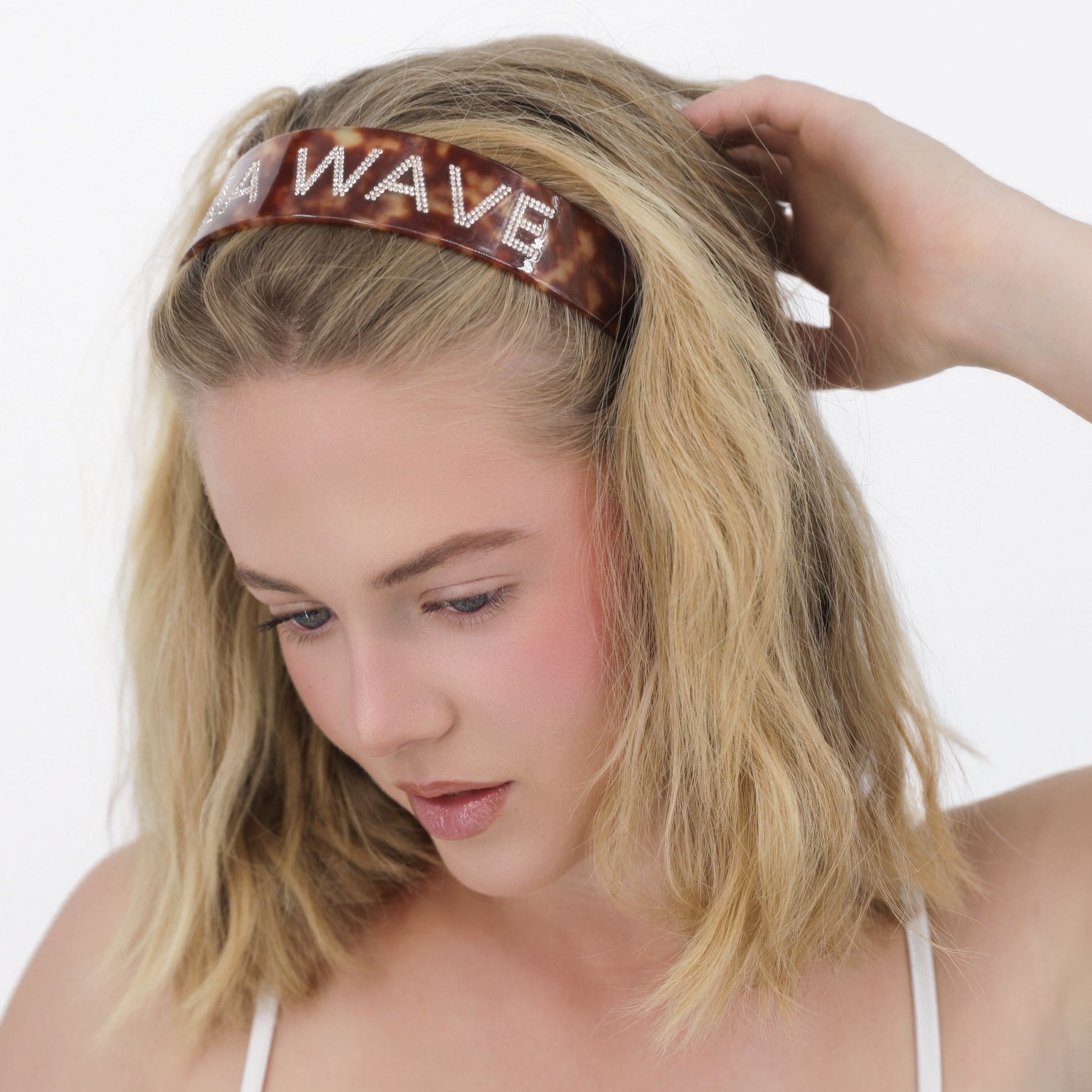 Woman wearing a Luna Wave red amber signature headband with 'LUNA WAVE' text on a white background