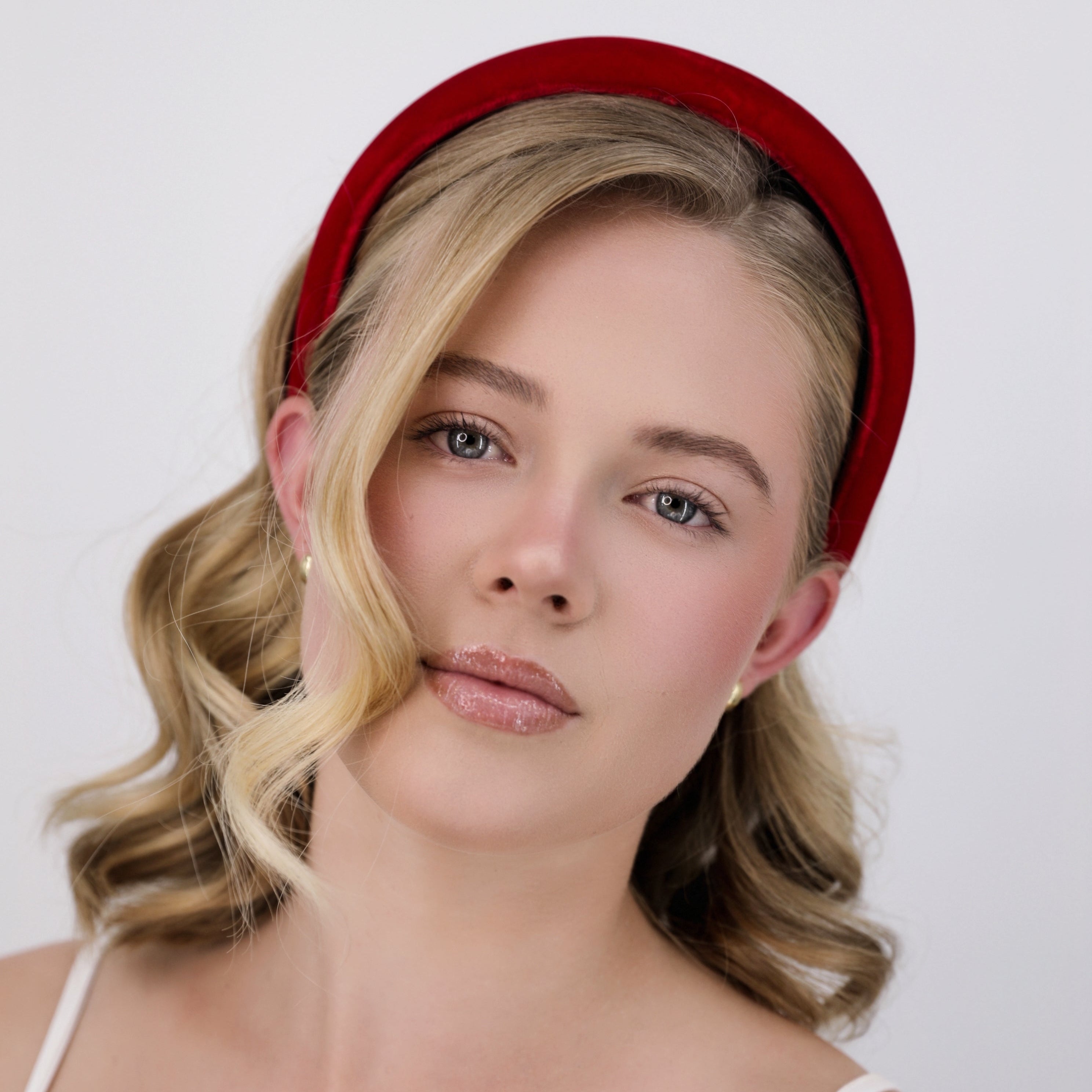 Woman wearing a Luna Wave red amelie headband against a white background