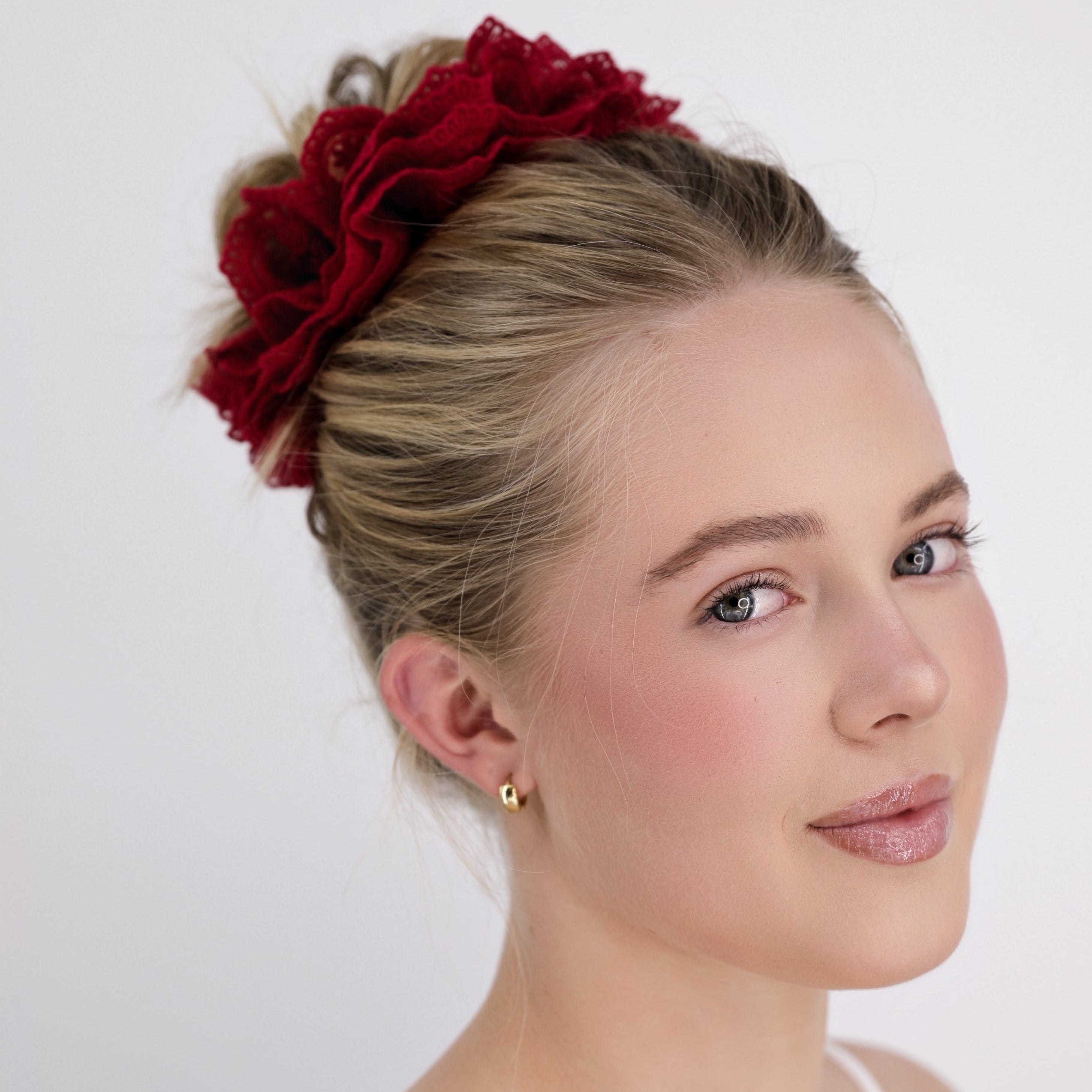 Woman with Luna Wave red burgundy lace scrunchie against a white background