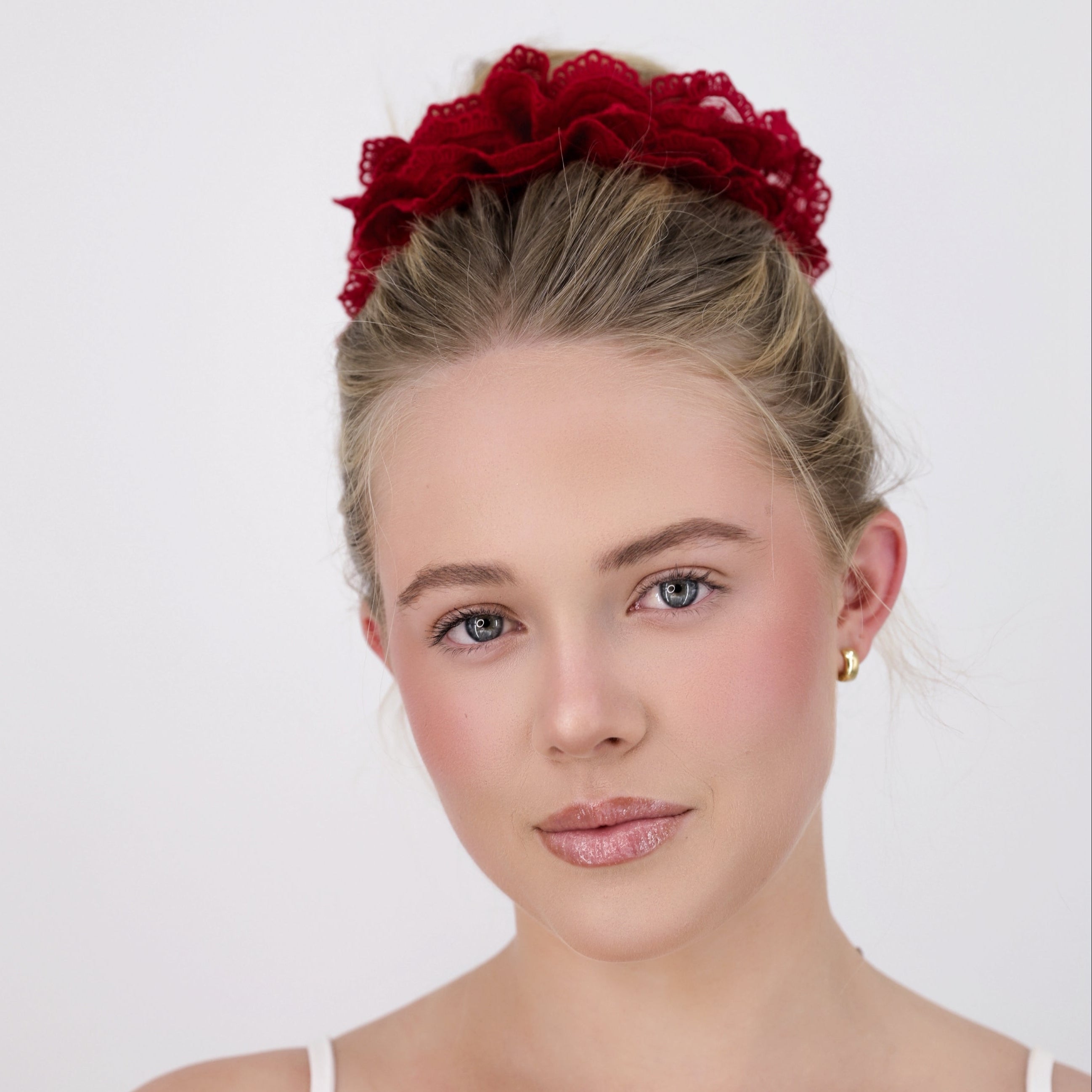 Woman with Luna Wave red burgundy lace scrunchie against a white background
